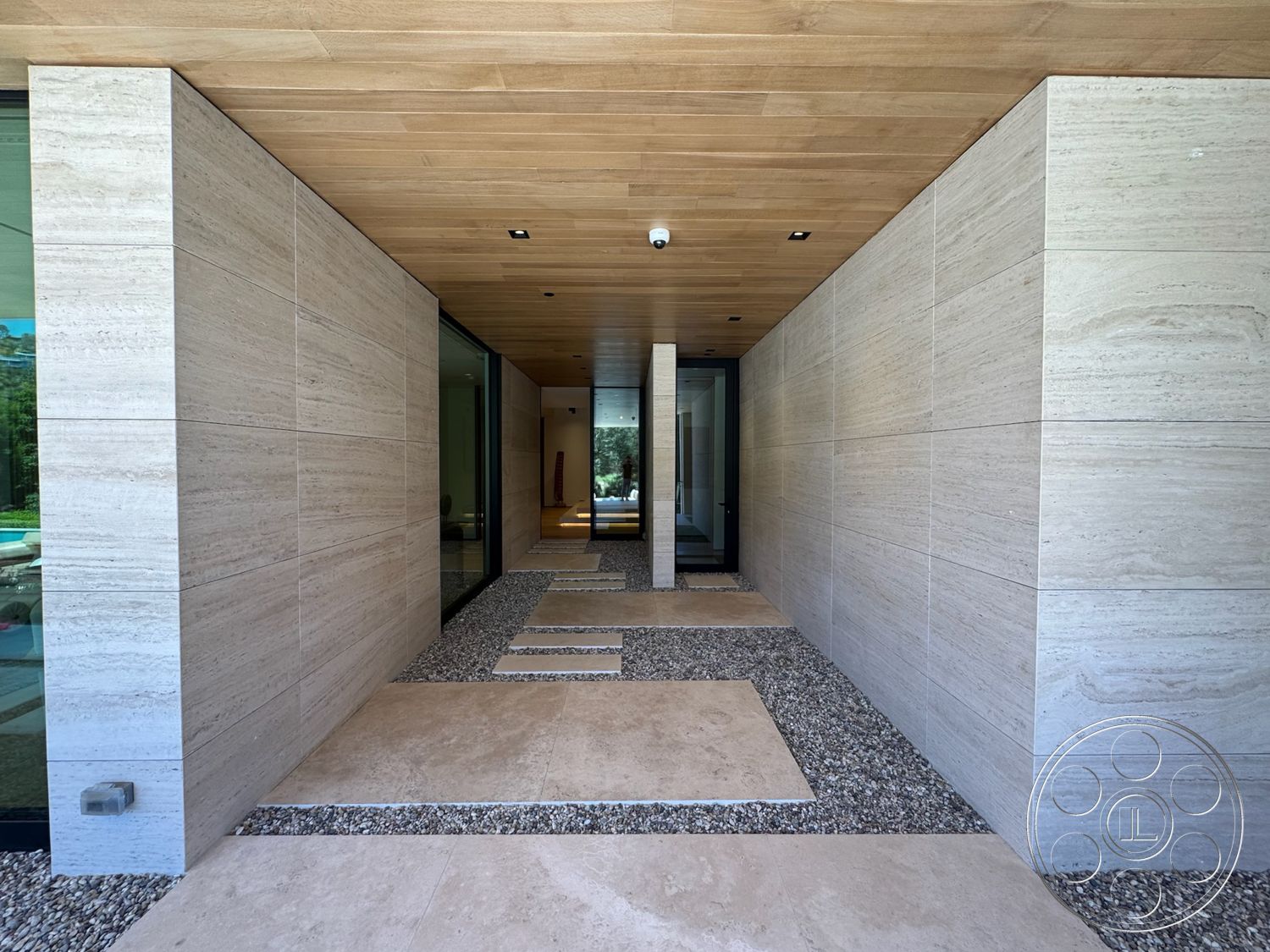 Chalon Estate - natural light, concrete flooring, gravel pathway, wood ceiling panels, modern architectural style, textured plaster walls, interior hallway, glass entrance door, stone wall cladding