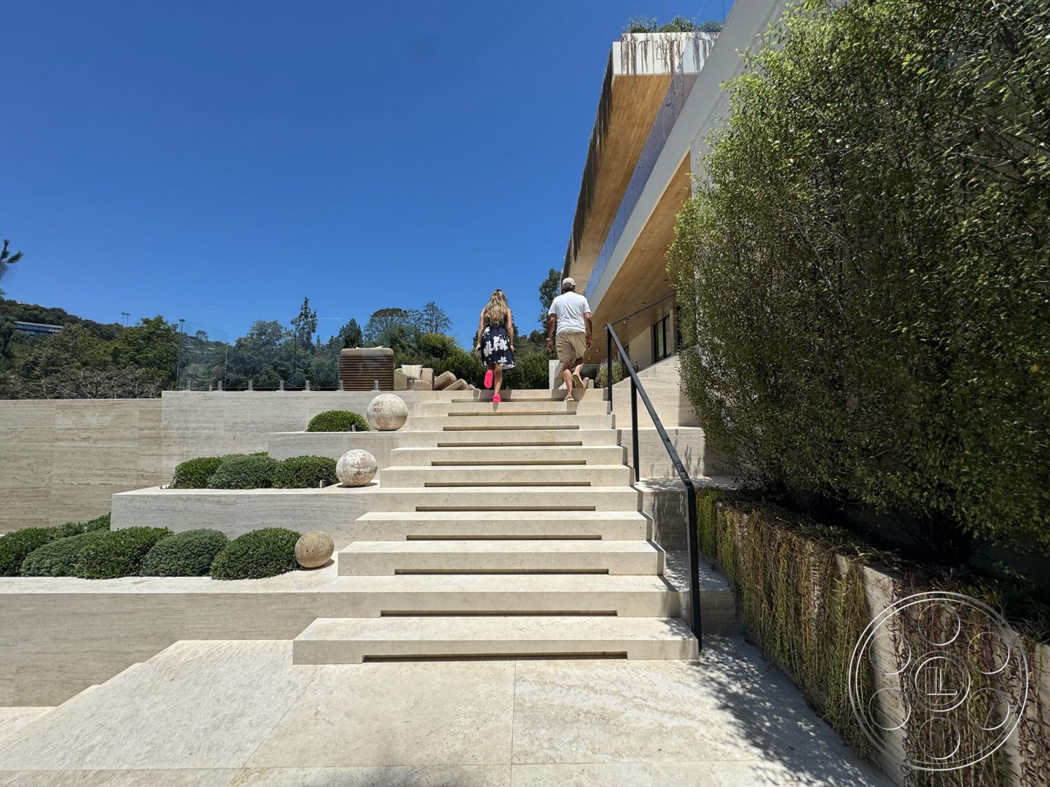 Chalon Estate - exterior, glass railing, outdoor greenery, concrete steps, sculptural garden elements, horizontal wood paneling, rectangular layout, minimalist architectural style, landscaped garden with shrubs, modern hillside setting