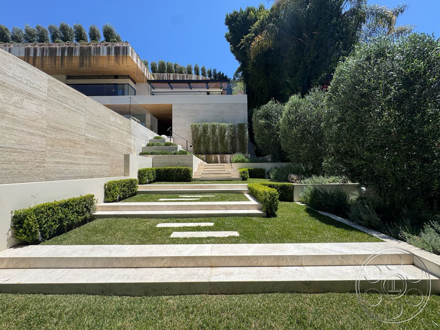 Chalon Estate - exterior, clean lines, landscaped garden beds, glass balcony railing, modern architectural design, contemporary home facade, manicured grass lawn, vertical garden wall, wood beam overhang, hedge privacy screening, limestone terrace steps, symmetrical step arrangement, level lawn terrace, geometric pathway, tiered landscaping