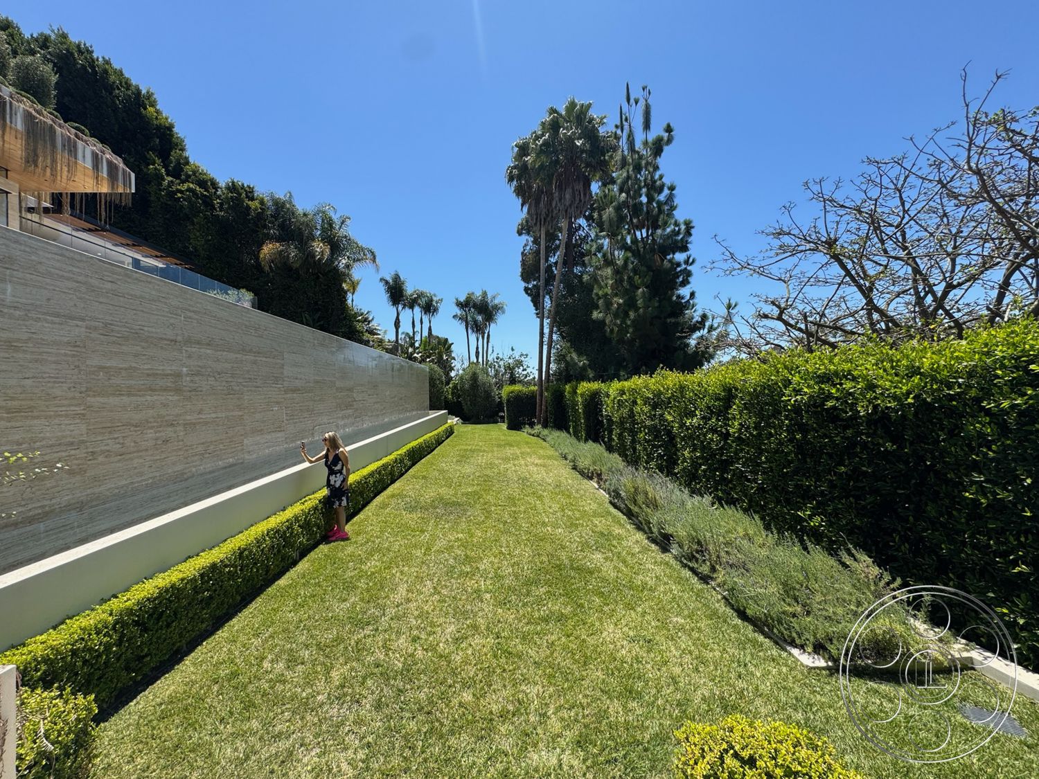 Chalon Estate - exterior, landscaped garden, palm trees, minimalist outdoor design, manicured grass lawn, boxwood hedge border, linear planting beds, porcelain tile wall, dry weathered landscape design