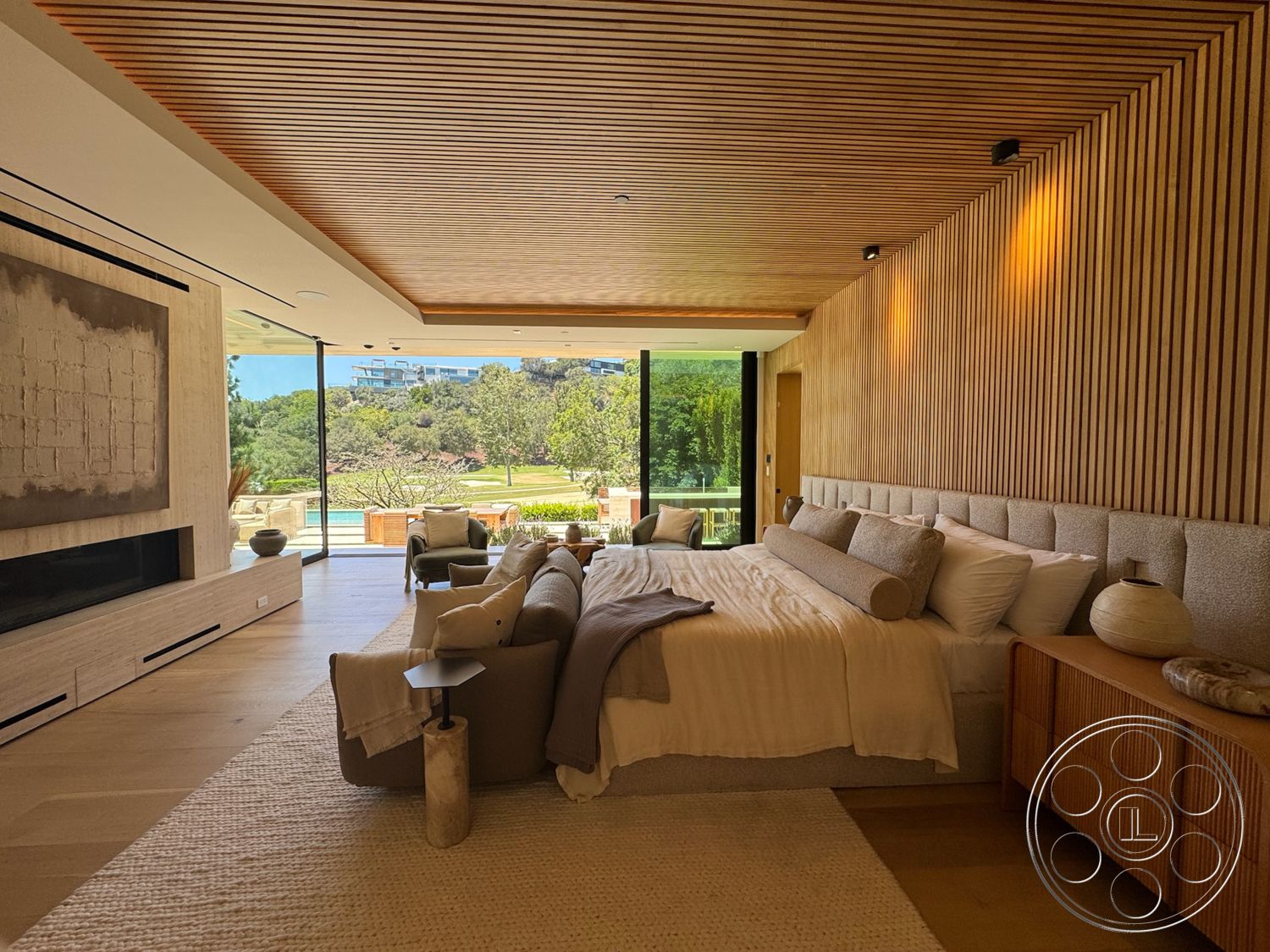 Chalon Estate - neutral color palette, open floor plan, wooden dresser, floor-to-ceiling windows, woven area rug, textured plaster walls, upholstered headboard, minimalist bedside table, natural light-filled room, modern accent chairs, landscape view through windows, light hardwood bedroom floors, wood slat ceiling, contemporary king-size bed, space for lounging, relaxed, modern atmosphere