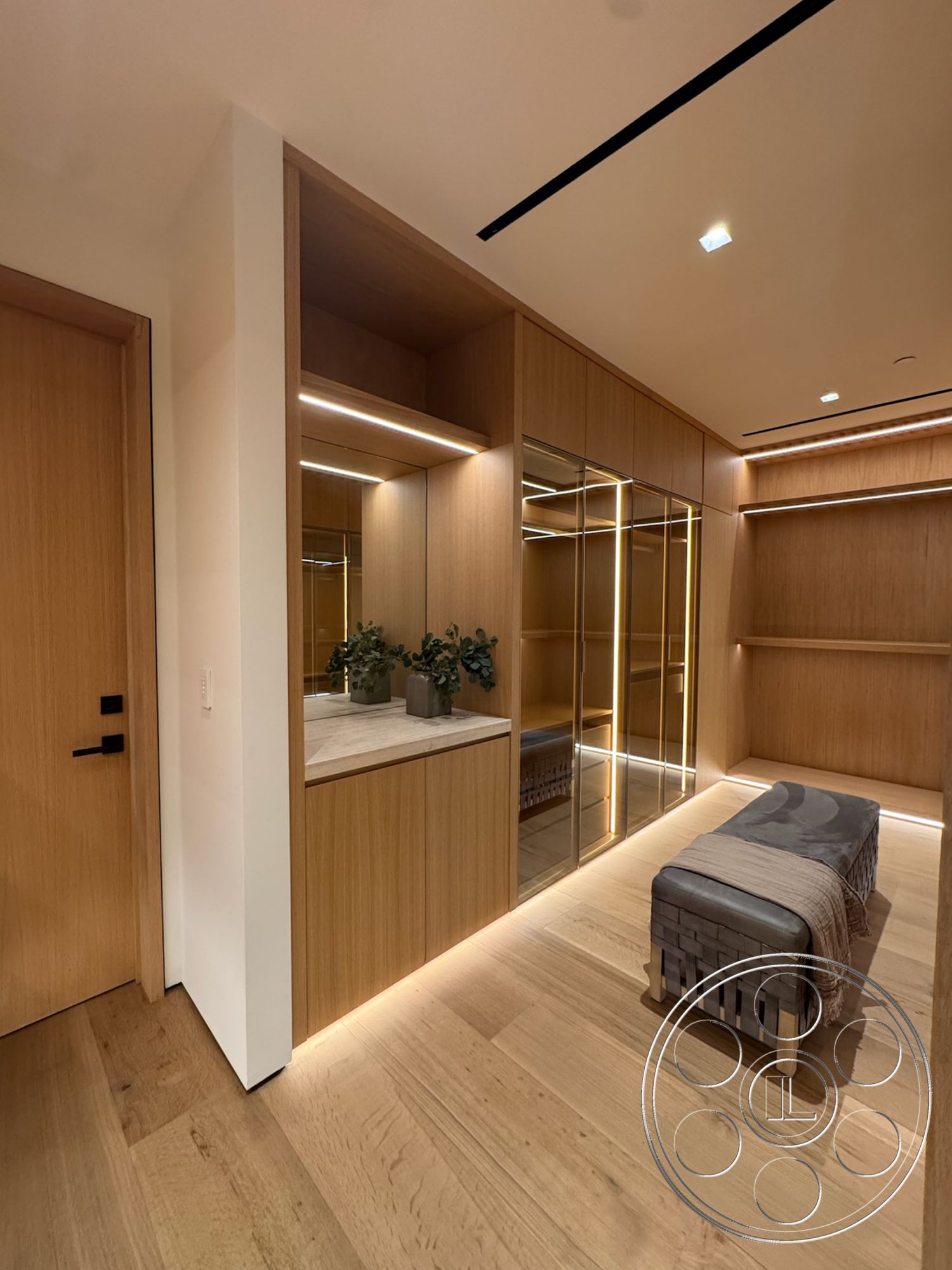 Chalon Estate - minimalist design, wood paneling, horizontal lines, built-in shelving, mirrored closet doors, decorative indoor plants, polished stone countertop, lightwood cabinetry, textured wooden floor, horizontal LED lighting, modern closet space