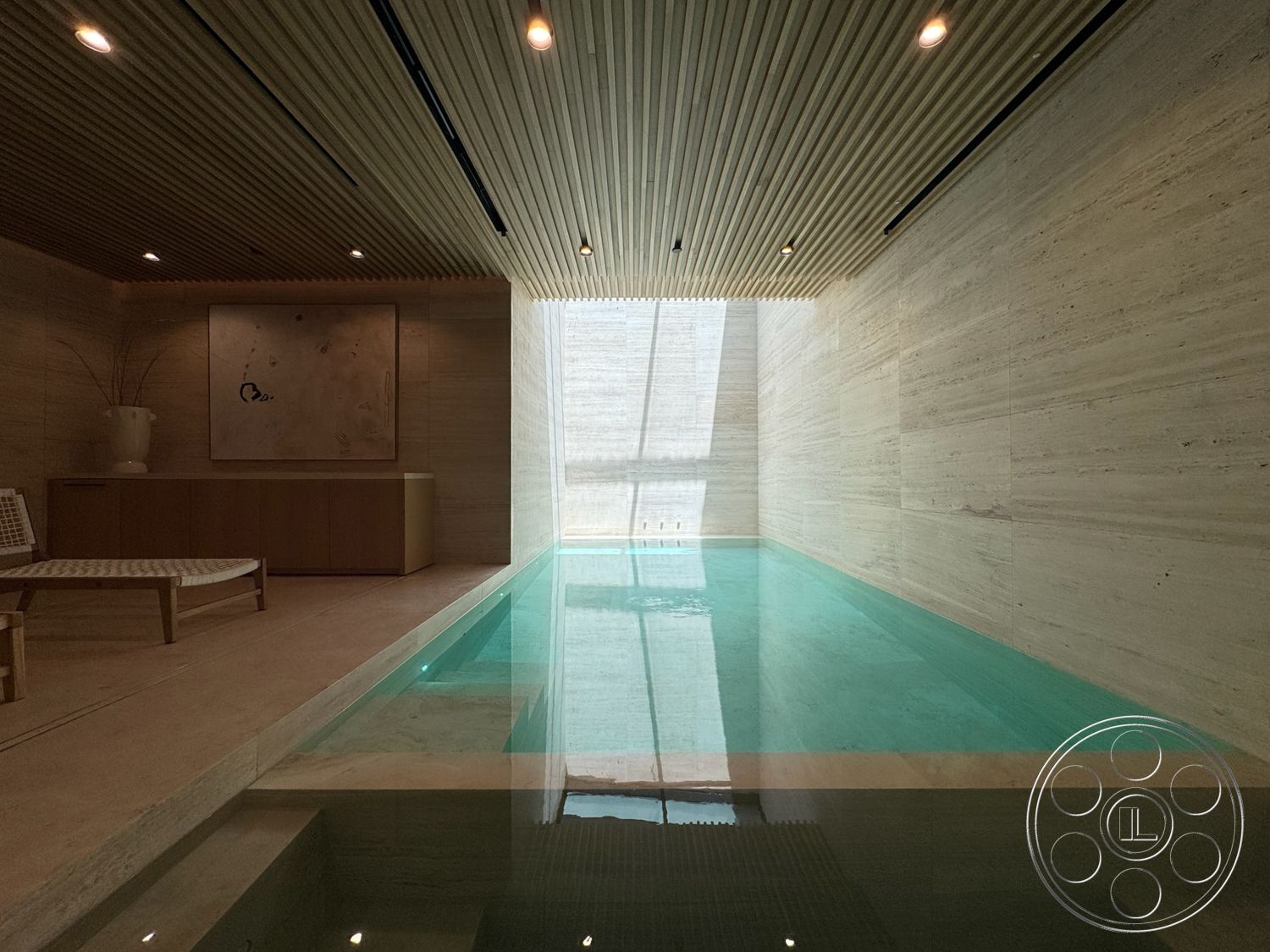 Chalon Estate - minimalist decor, modern aesthetic, marble flooring, ambient recessed lighting, wood slat ceiling, limestone walls, concrete pool with glass edge, built-in wooden storage cabinet, natural light through large window