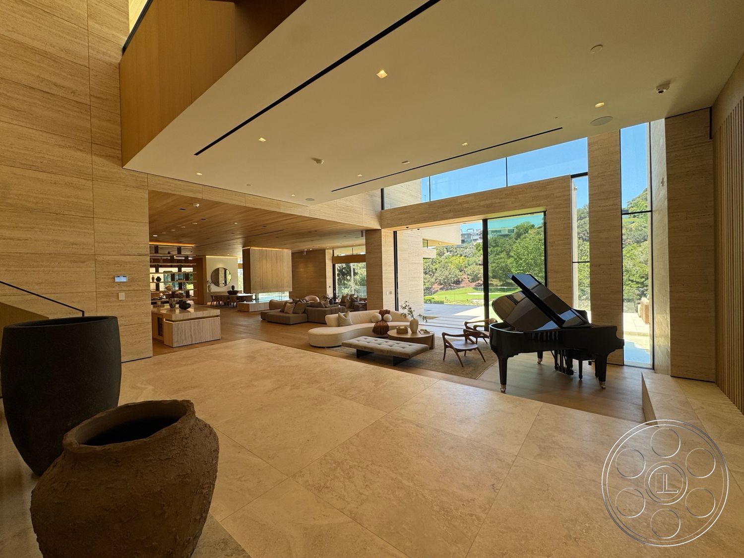 Chalon Estate - neutral color palette, natural light, minimalist design, modern furniture, cozy seating area, textured wall accents, modern coffee table, floor-to-ceiling windows, marble flooring, elegant lighting fixtures, geometric ceiling design, tall ceiling, contemporary art decor, built-in shelving units, large open floor plan, wood panel walls, plantation setting, piano as focal feature, sculptural planters