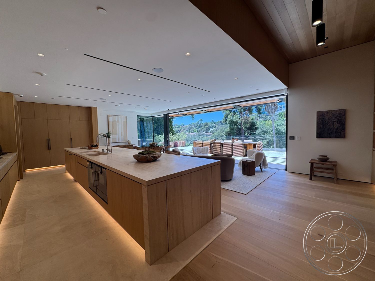Chalon Estate - modern kitchen, hardwood flooring, recessed lighting, minimalist design, open concept layout, light wood cabinetry, floor-to-ceiling windows, stone countertop, marble kitchen island, natural light from sliding glass doors, vaulted ceiling with wood panels, outdoor view of landscaped area