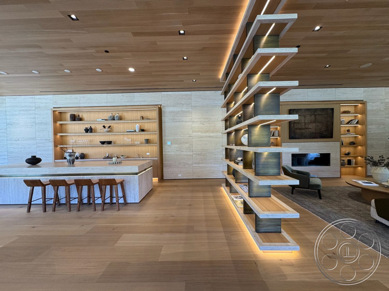 Chalon Estate - neutral color palette, wooden bar stools, stone accent wall, textured accent wall, natural wood flooring, contemporary coffee table, concrete kitchen island, recessed lighting fixtures, wood plank ceiling, LED strip lighting, light wood shelving units, open bookshelf design, minimalist living room layout