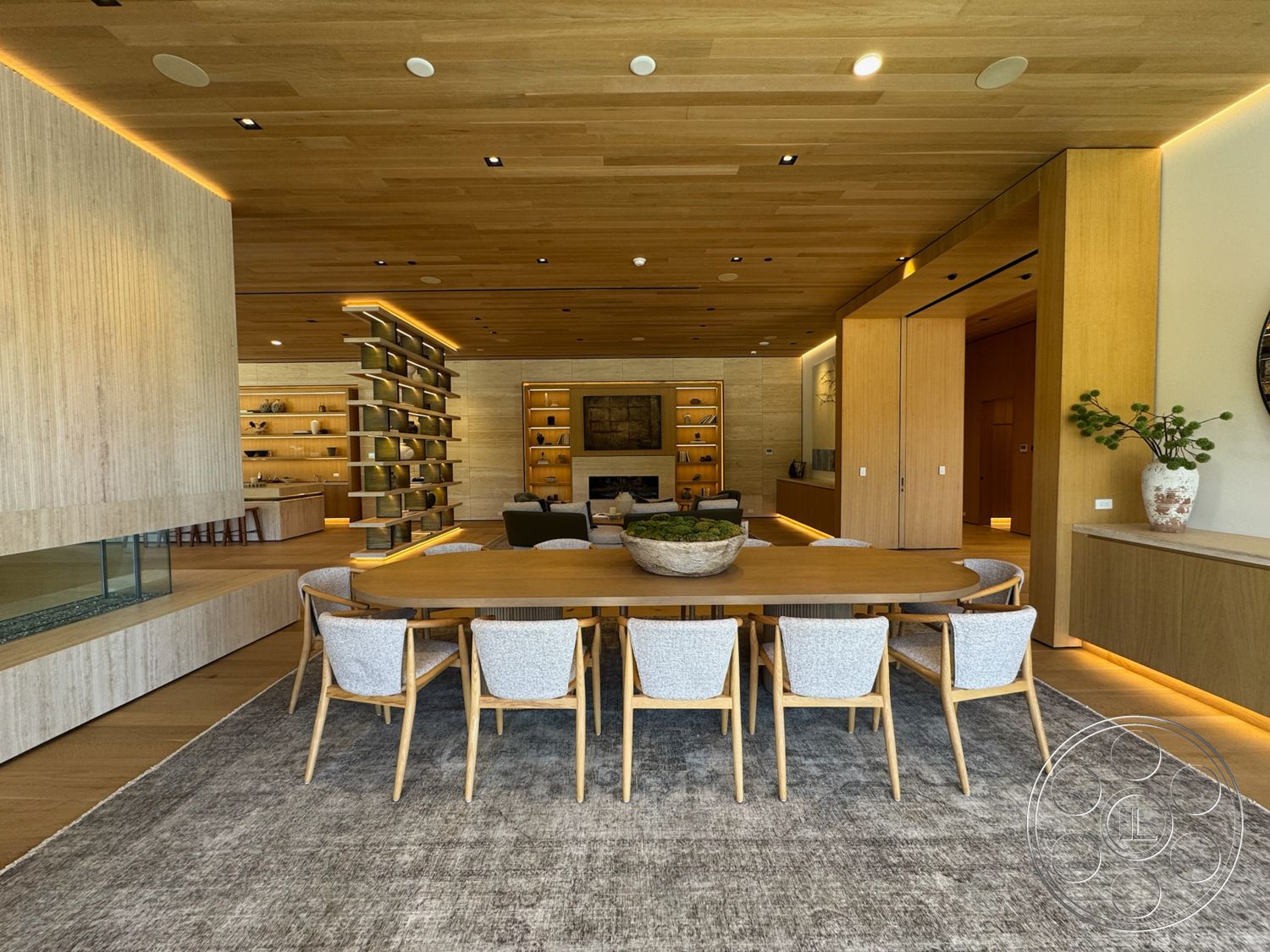 Chalon Estate - neutral color palette, natural light, recessed lighting, textured area rug, open floor plan, upholstered dining chairs, built-in bookshelf, light wood paneling, oak dining table, modern minimalist design, wood beam ceiling, glass fireplace front