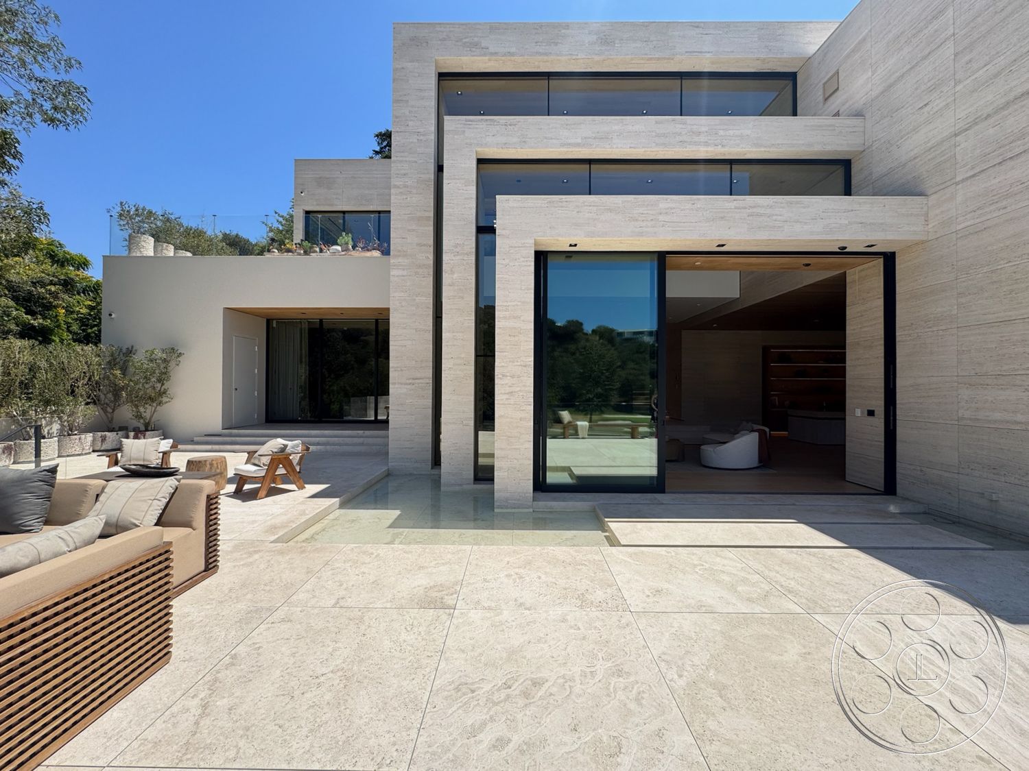 Chalon Estate - exterior, flat roof, glass sliding doors, concrete facade, landscaped garden setting, tall floor-to-ceiling windows, travertine stone patio flooring, rectangular home design, horizontal wood slat seating