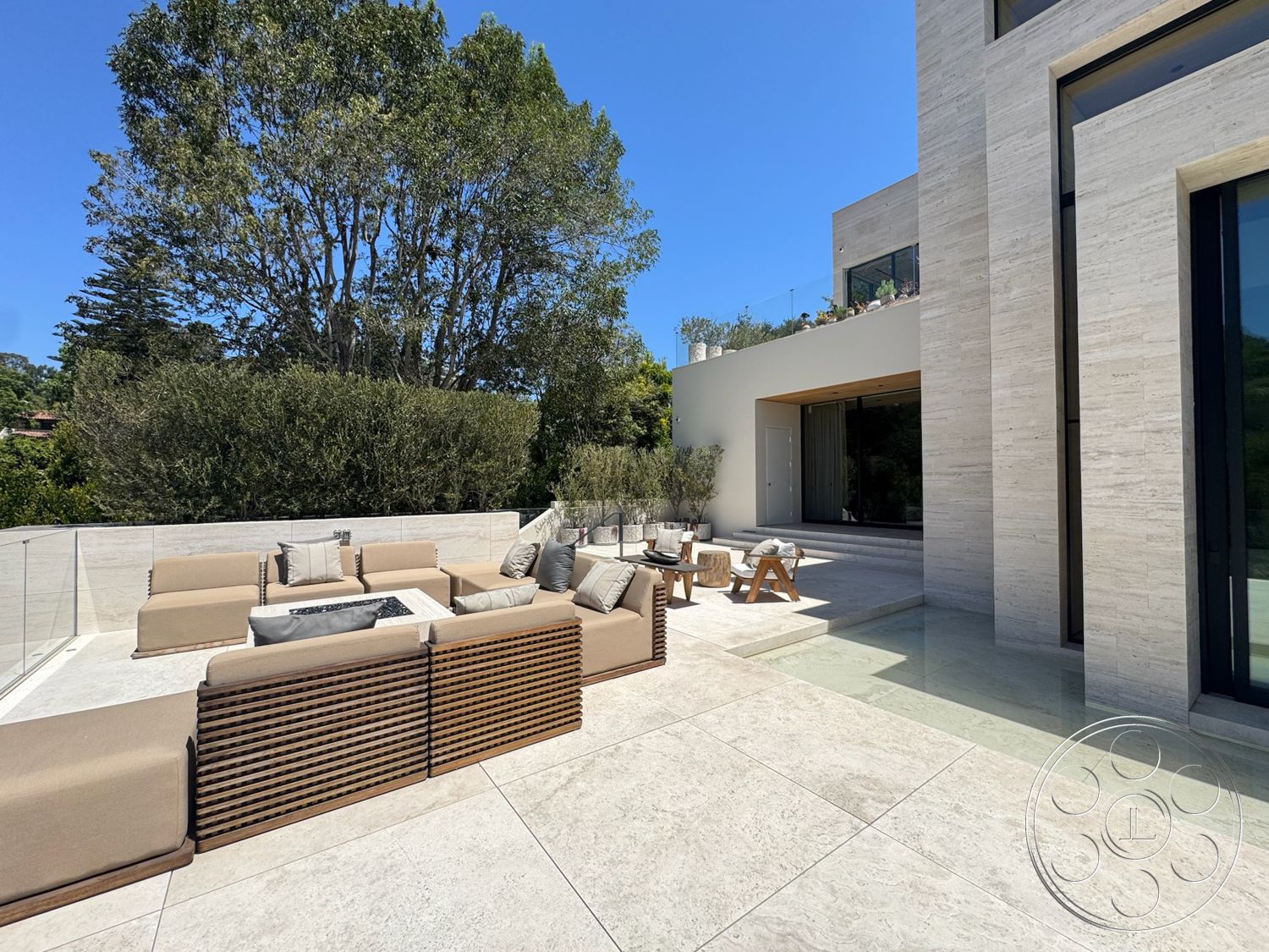 Chalon Estate - exterior, glass railing, fire pit table, decorative throw pillows, natural stone wall, large sliding glass doors, flat roof design, landscaped garden setting, modern outdoor seating area, minimalist architectural style, travertine patio flooring, sectional outdoor sofa, wood ceiling overhang