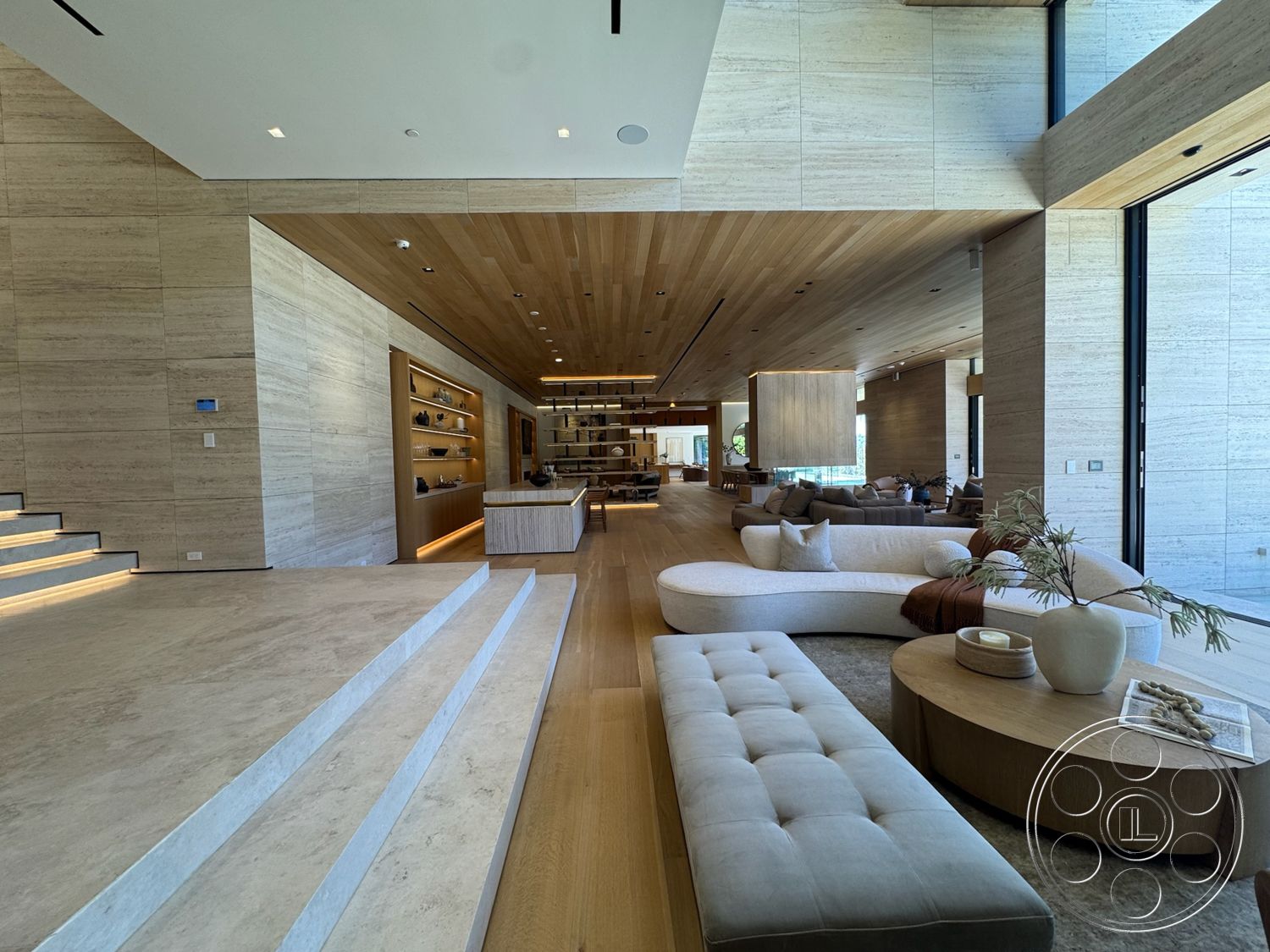 Chalon Estate - exterior, round coffee table, floor-to-ceiling windows, textured wall finishes, light beige marble flooring, curved sectional sofa, minimalist interior design, built-in shelving unit, open floor plan living area, floating stairs, natural stone wall cladding, wood slatted ceiling, concealed lighting accents, wooden accent pieces