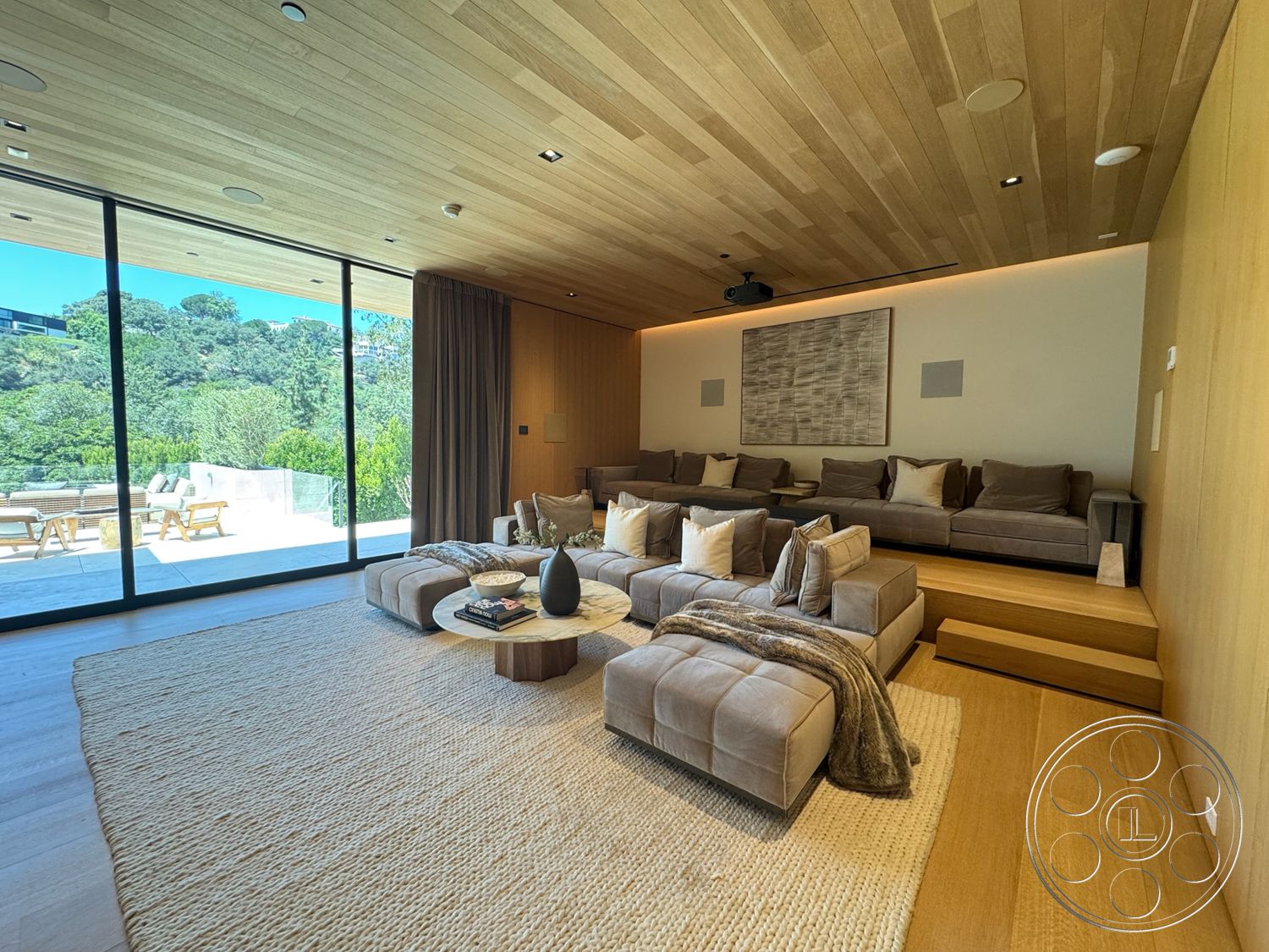 Chalon Estate - neutral color palette, wood accent wall, contemporary coffee table, outdoor patio view, interior living room, minimalist interior design, floor-to-ceiling glass windows, plush beige area rug, soft beige sectional sofa, exposed wood ceiling treatment, light wood plank ceiling, natural fiber woven rug