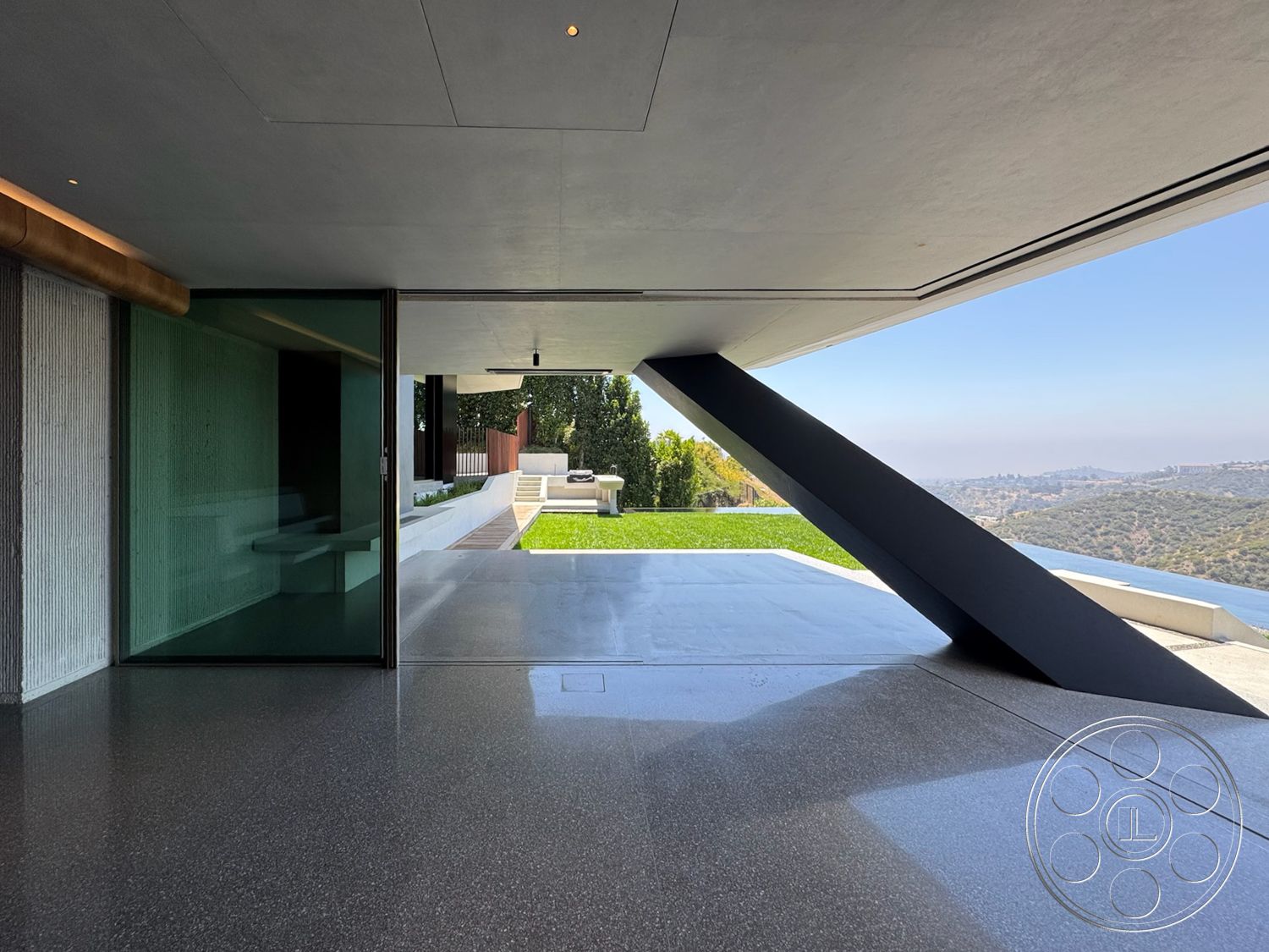 Modern 516 - exterior, polished concrete flooring, glass sliding doors, outdoor seating area, concrete walls, floor-to-ceiling windows, modern architectural style, mountain view, landscaped lawn, steel support beams, horizontal wood fence
