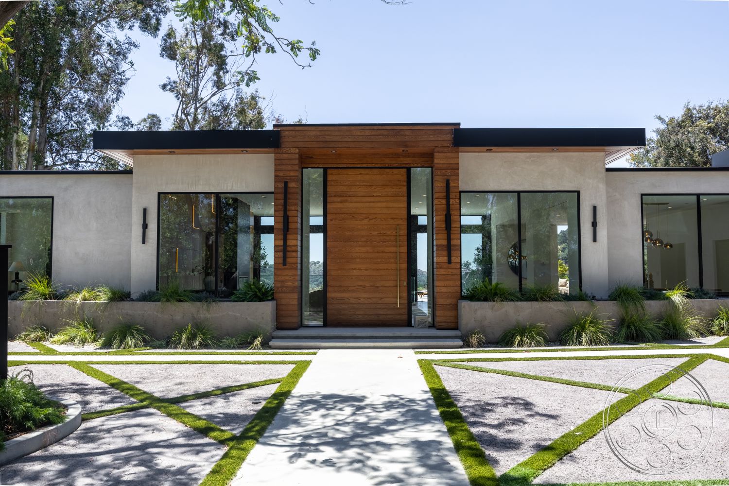 Canyon House - exterior, flat roof, minimalist design elements, large glass windows, modern architectural style, symmetrical facade, concrete walkway, stucco walls, gravel driveway, wood front door, low-profile planters, landscaped garden with grass