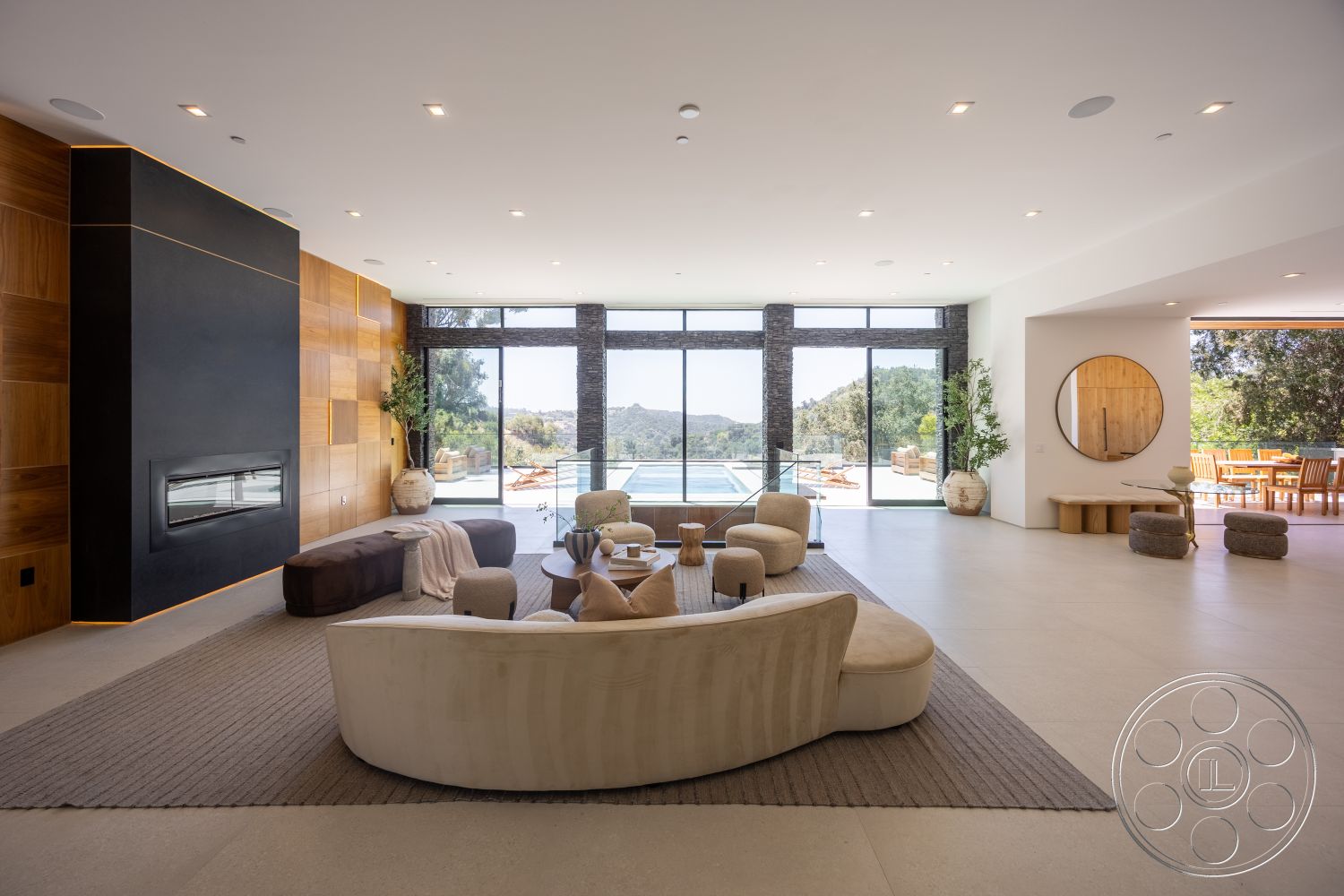 Canyon House - neutral color palette, natural light, indoor plants, area rug, concrete flooring, wooden dining table, floor-to-ceiling windows, mountain view, elegant lighting fixtures, modern fireplace, minimalist coffee table, stone feature wall, curved seating, open concept living area, exposed wood paneling, rounded sectional sofa