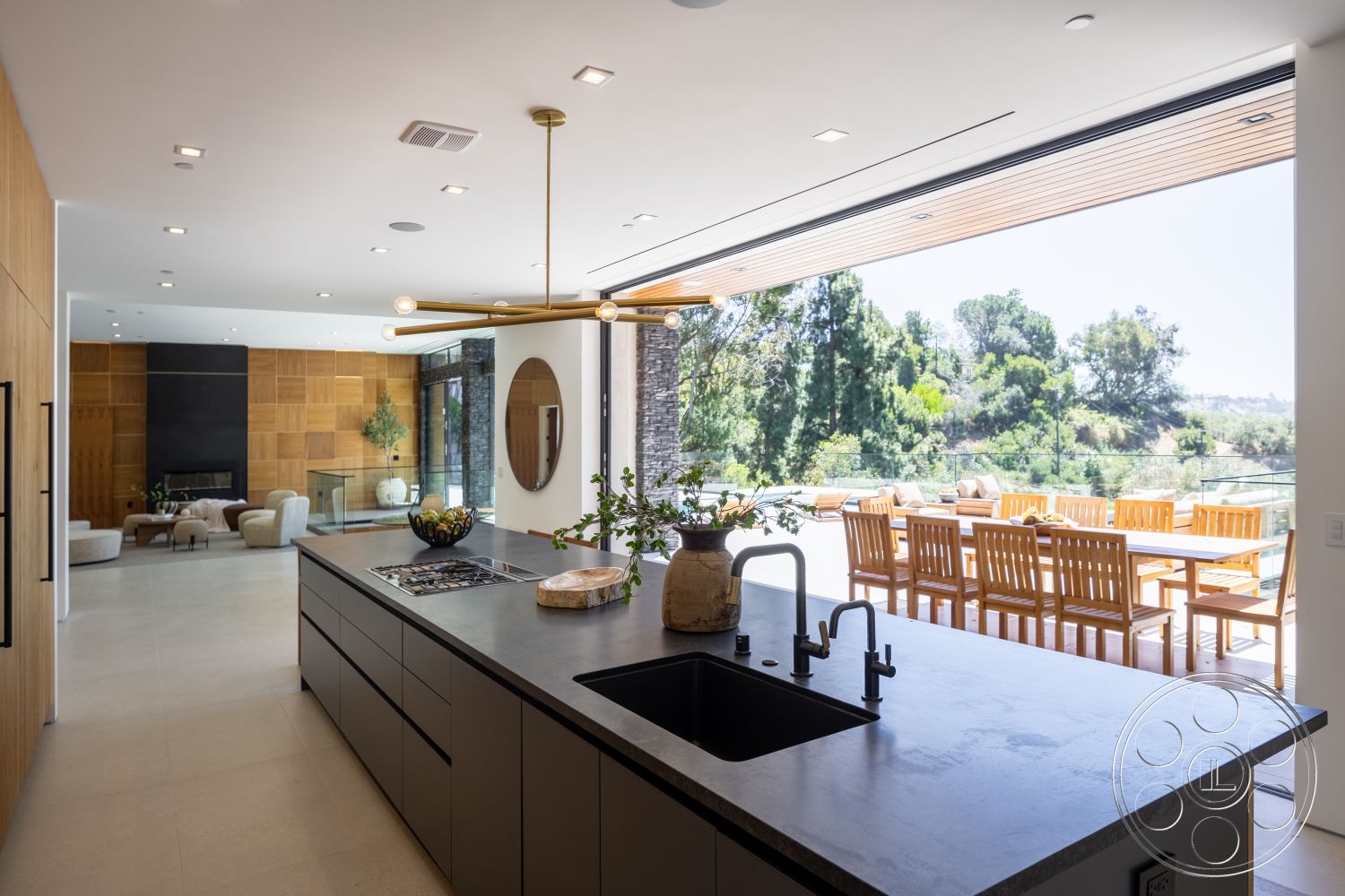 Canyon House - neutral color palette, hardwood flooring, open concept layout, modern pendant lighting, outdoor dining area, seamless indoor-outdoor flow, wood ceiling beams, minimalist kitchen design, floor-to-ceiling glass windows, surrounding greenery view, concrete kitchen countertops, wood patio furniture, flat panel cabinetry, decorative wooden wall paneling