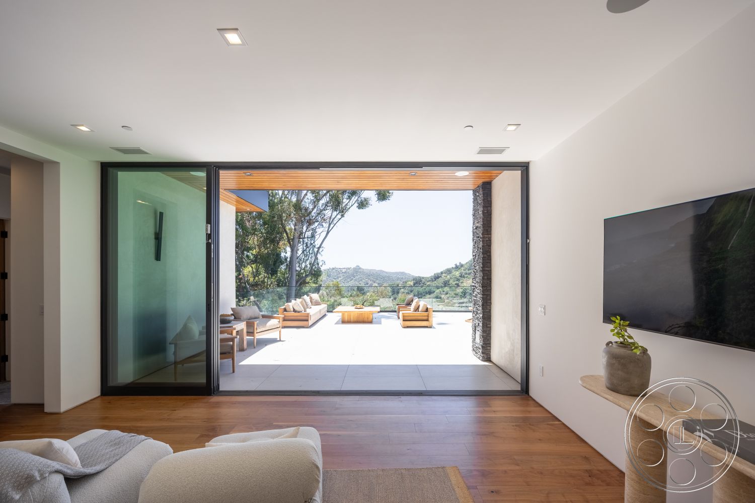 Canyon House - minimalist design, stone accent wall, contemporary furniture, open floor plan, floor-to-ceiling windows, sliding glass door, mountain view, textured plaster walls, light wood ceiling, exposed wood ceiling beams, hardwood living room floors, white painted walls, outdoor patio area