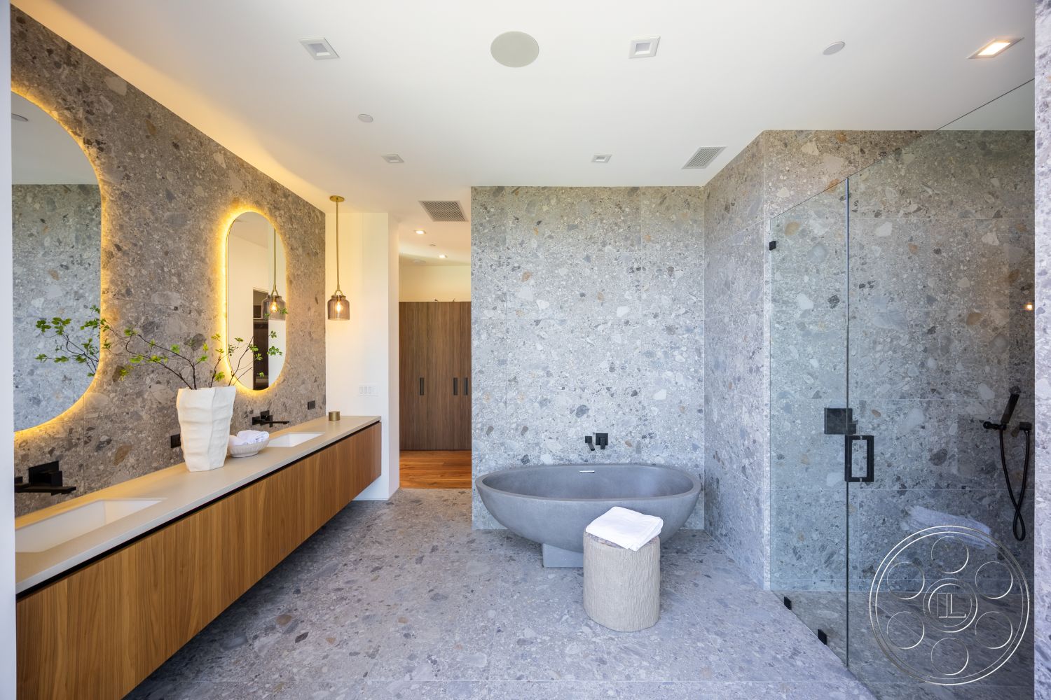 Canyon House - dark wood cabinetry, glass shower enclosure, textured stone flooring, white quartz countertop, pendant lighting fixtures, floating wooden vanity, natural greenery decor, exposed aggregate stone walls, freestanding concrete bathtub, framed mirrors with lighting