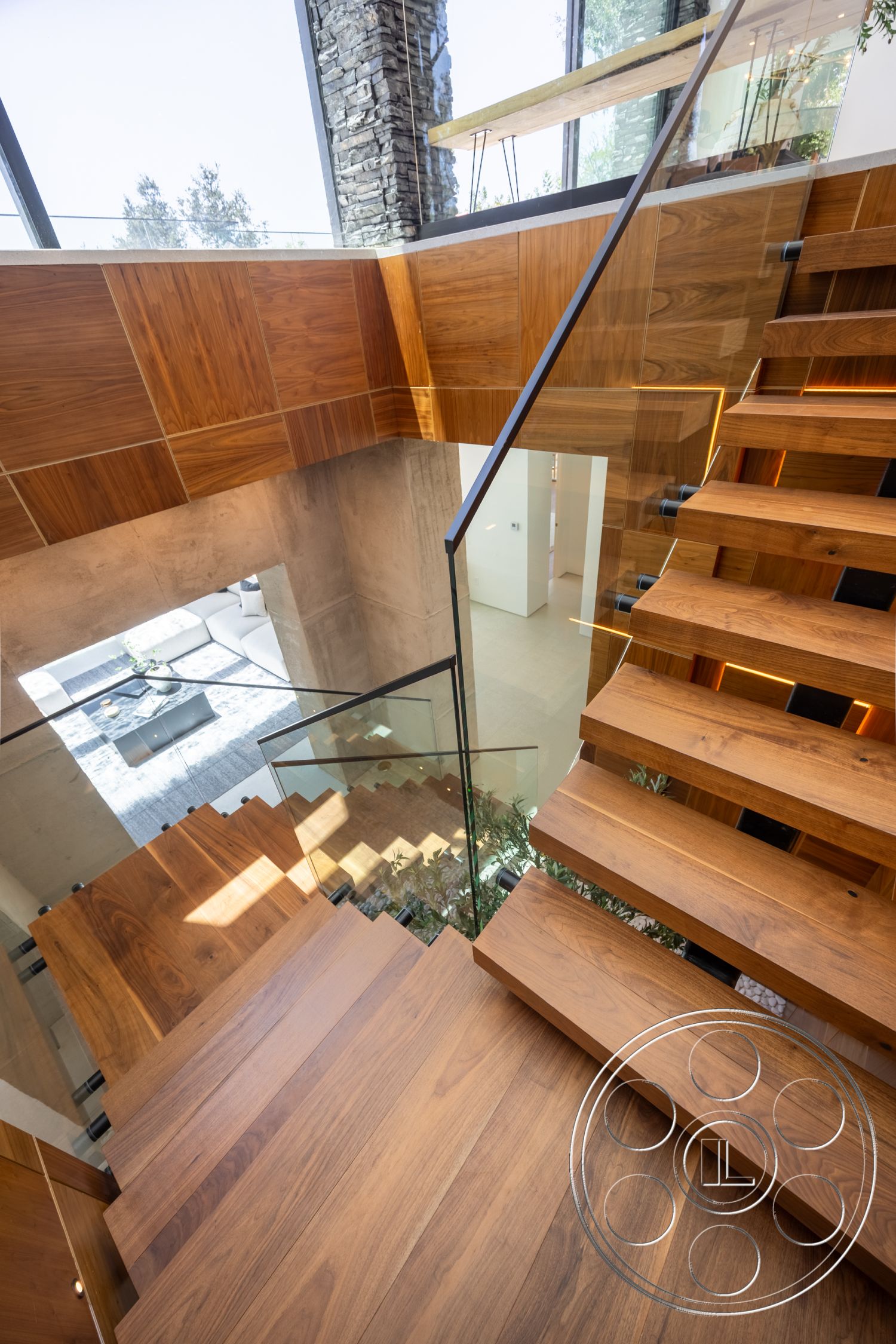 Canyon House - minimalist aesthetic, exposed concrete walls, industrial design elements, modern architectural style, natural light from large windows, glass stair railing, wood panel accent wall, hardwood staircase treads, floating staircase design