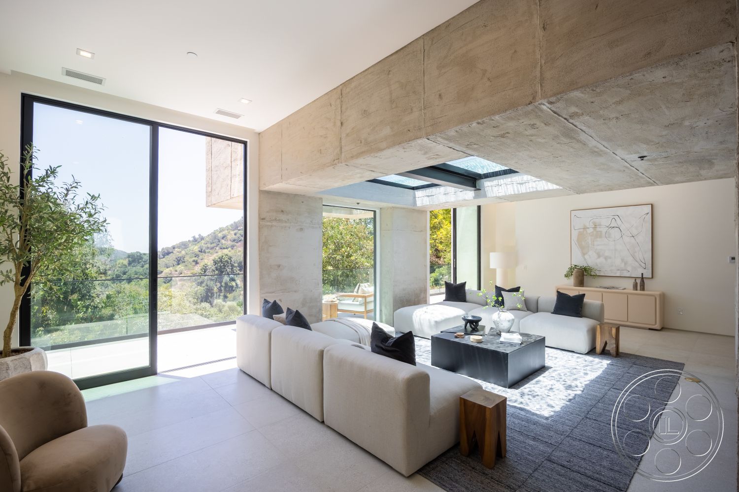 Canyon House - neutral color palette, natural light, exposed concrete walls, concrete ceiling, floor-to-ceiling glass windows, textured concrete floor, contemporary art on wall, outdoor mountain view, minimalist living room, black accent coffee table, light-colored fabric sofas