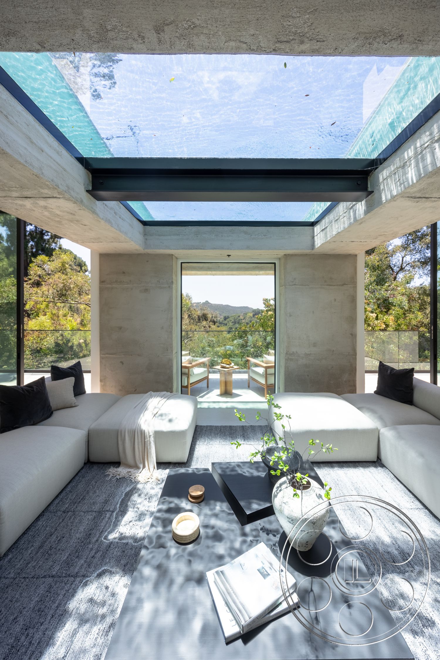 Canyon House - minimalist decor, textured area rug, open floor plan, exposed concrete walls, floor-to-ceiling windows, outdoor view, concrete ceiling, glass skylight, wood accent table, interior living room, modern sectional sofa, natural light orientation