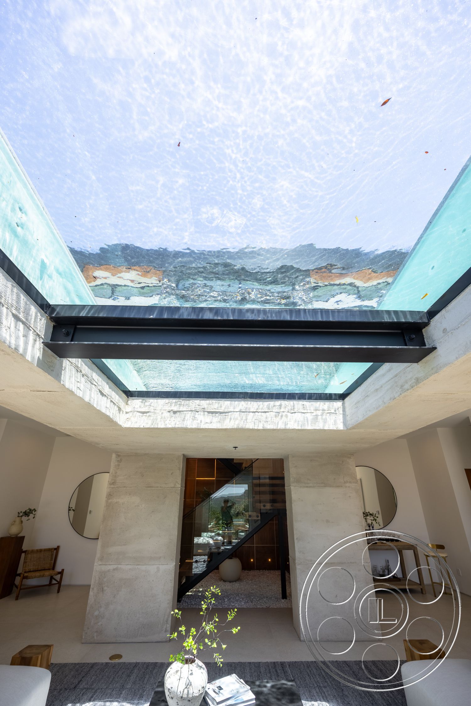 Canyon House - minimalist decor, exterior, concrete walls, linear design elements, modern architectural style, floating staircase, glass skylight, open interior space, natural light infusion, neutral tile flooring, exposed concrete pillars, round mirror wall art