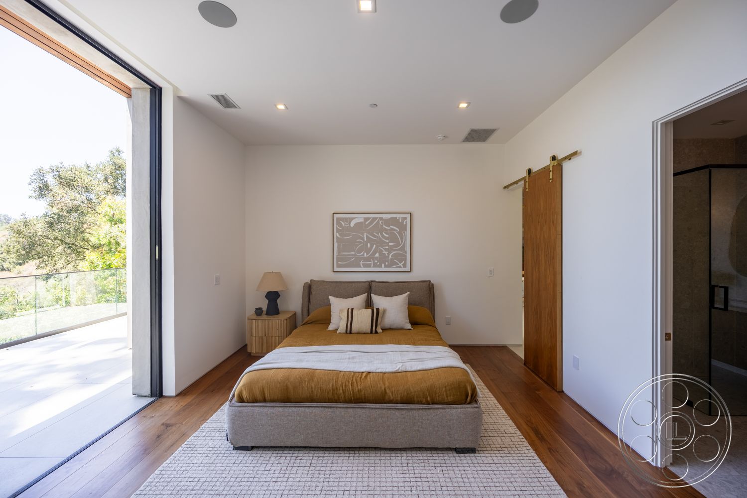 Canyon House - floor-to-ceiling windows, textured throw pillows, framed wall art, king-sized bed, sliding barn door, hardwood bedroom floors, white painted walls, glass balcony railing, modern bedside lamp