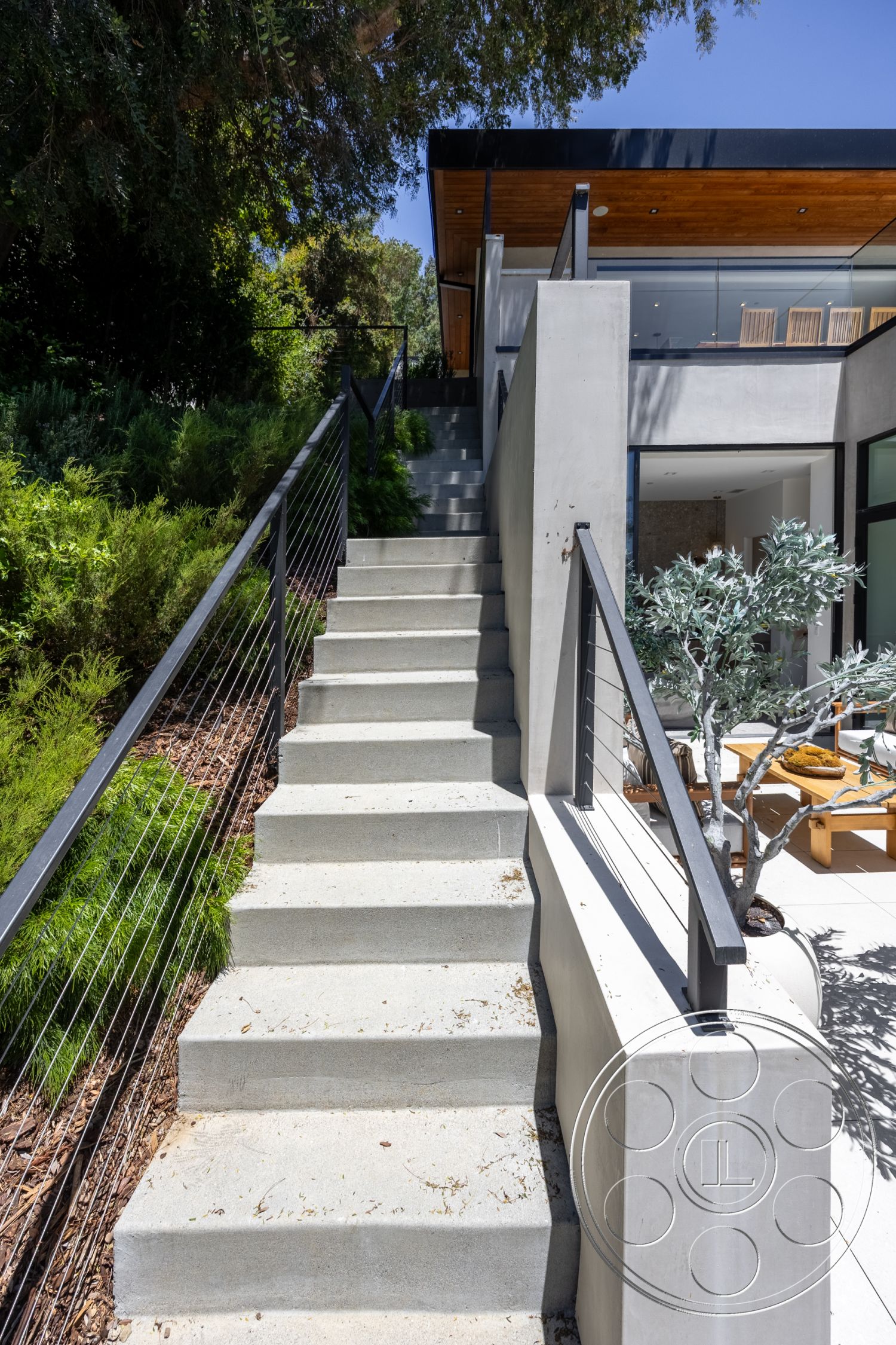 Canyon House - exterior, landscaped garden, modern architecture, concrete stairs, floor-to-ceiling windows, steel railing, concrete retaining wall, flat roof design, natural stone ground cover, wood ceiling details