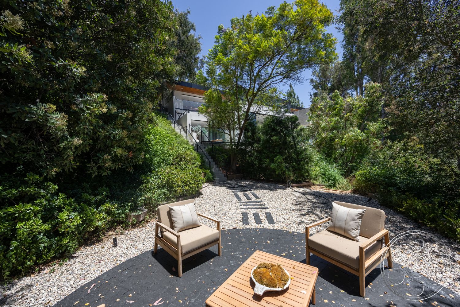 Canyon House - natural light, exterior, outdoor seating area, surrounding greenery, lush landscaping, concrete stepping stones, wooden outdoor furniture, gravel patio flooring, urban garden setting, modern home facade, elevated deck access