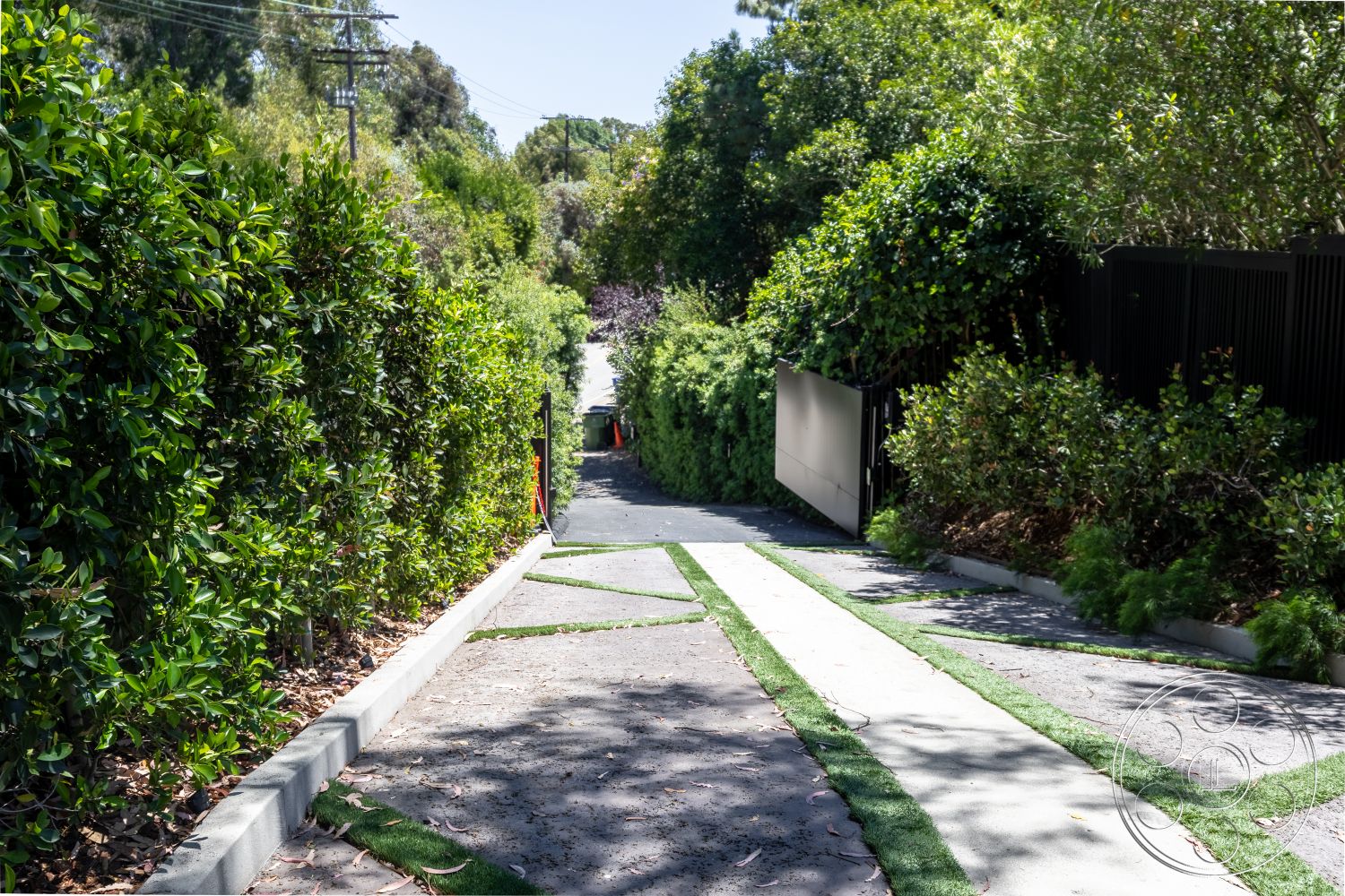 Canyon House - exterior, landscaped greenery, concrete pathway, concrete driveway, asphalt road, hedge borders, green grass strips, tropical planting, textured gravel surface, modern metal gate