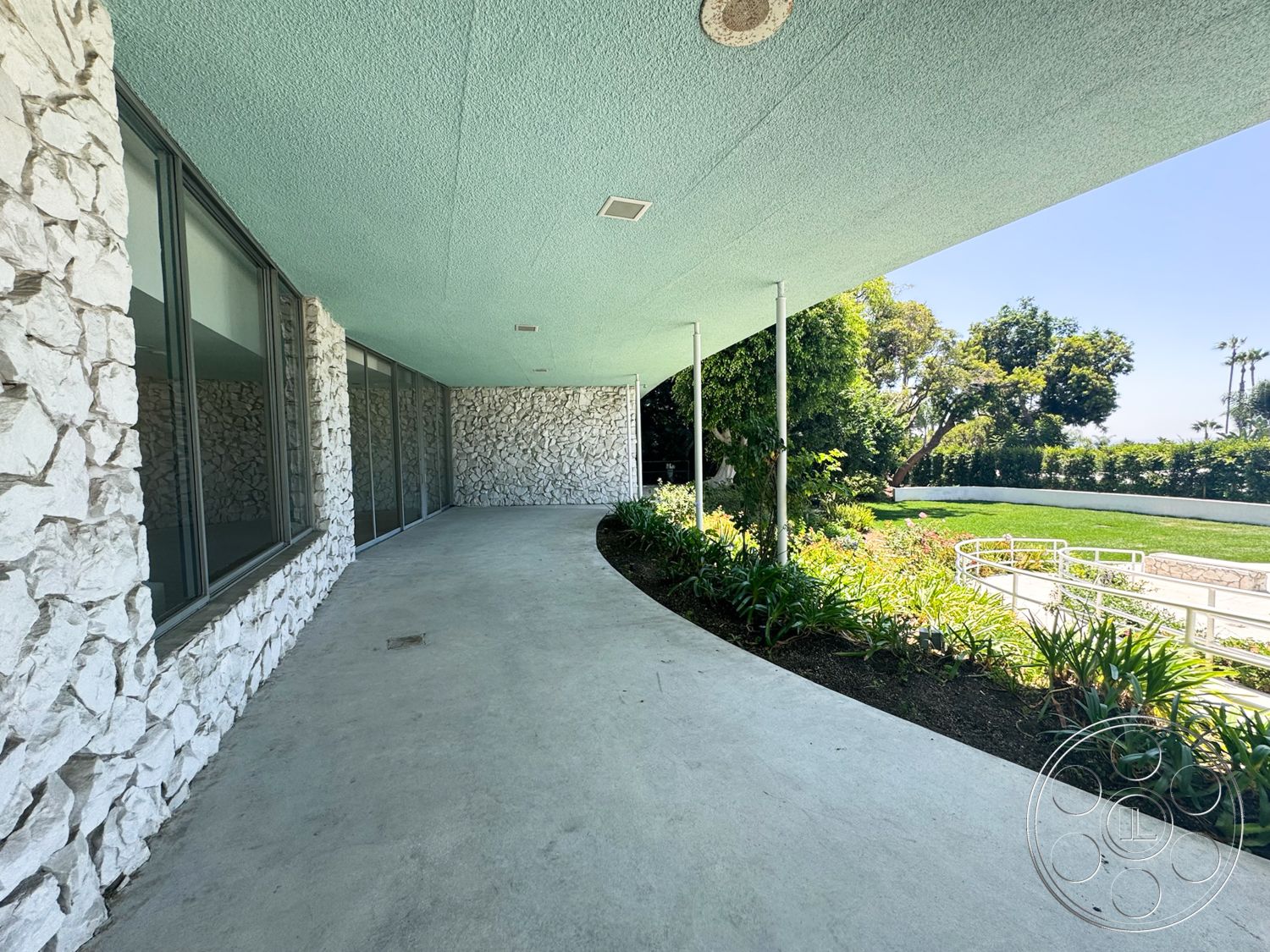 MCM 28 - exterior, landscaped garden, stone accent wall, modern architectural style, open outdoor space, textured ceiling, curved walkway, concrete patio floor, glass window panels