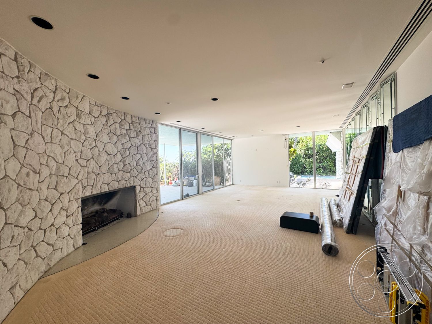 MCM 28 - floor-to-ceiling windows, modern architectural style, curved wall design, white painted walls, stone fireplace wall, carpet living room flooring