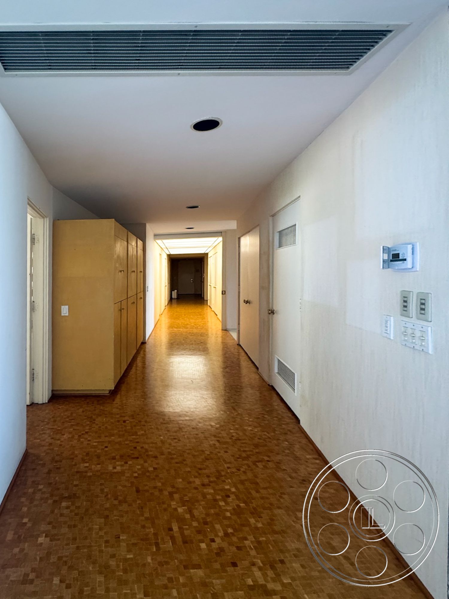 MCM 28 - neutral color palette, recessed lighting, wood parquet flooring, plain white walls, interior hallway, built-in wooden cabinetry, linear hallway design, exposed duct ceiling, panel doors, light-colored wood trim