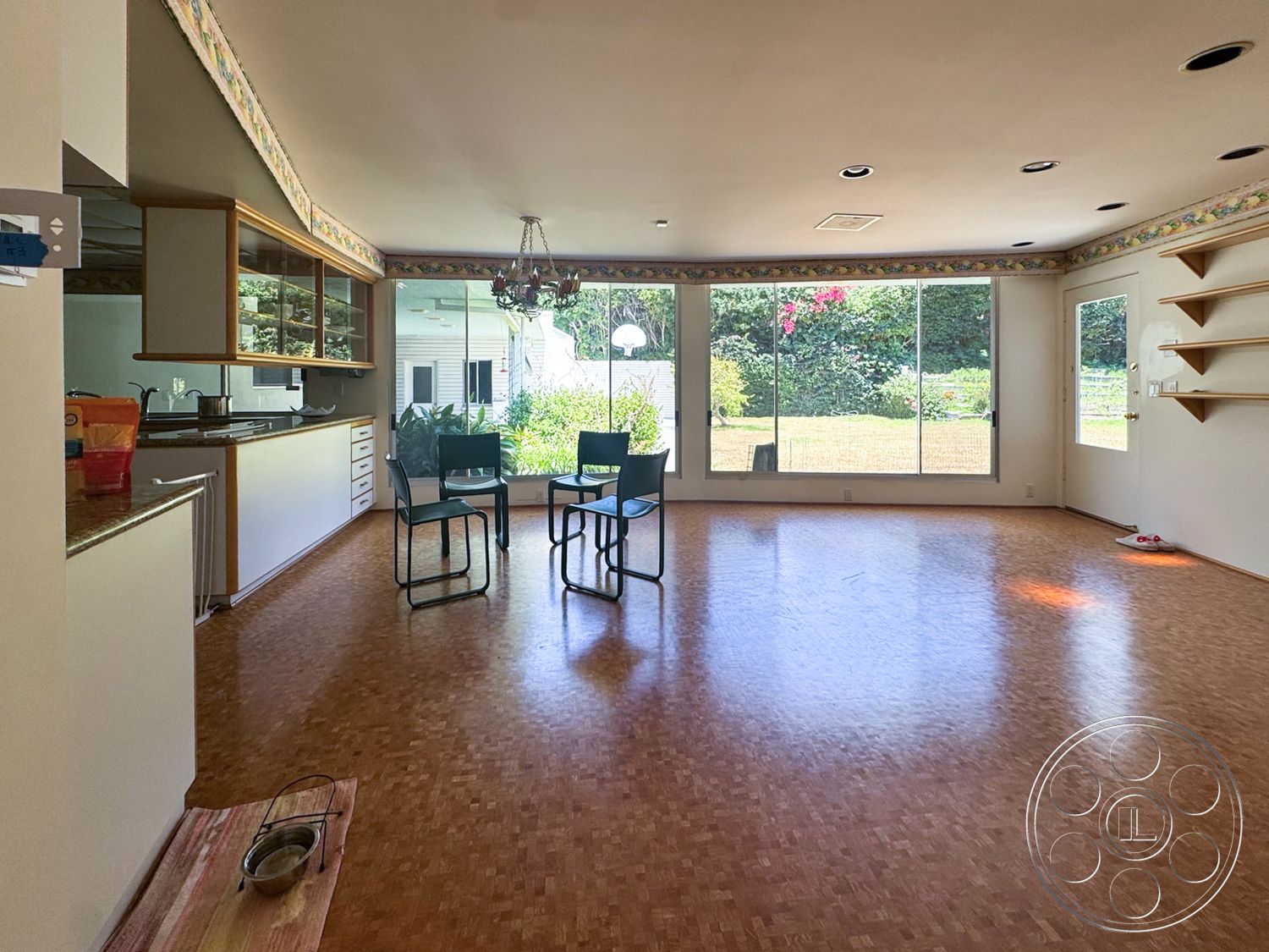 MCM 28 - minimalist decor, natural light, open floor plan, large glass windows, casual dining area, wooden shelving, modern light fixture, painted walls, bamboo flooring, kitchen area with countertop, access to outdoor garden