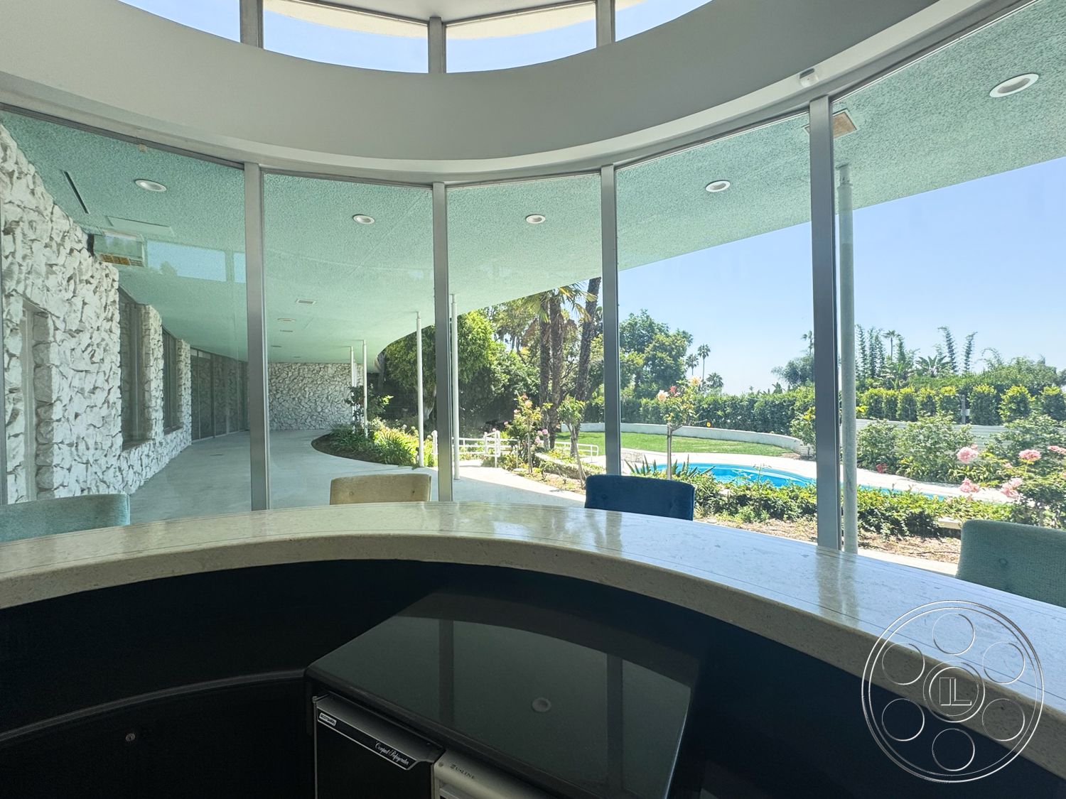 MCM 28 - natural light, landscaped garden, glass walls, modern design elements, interior space, infinity pool, poolside view, exposed stone wall, stone patio flooring, granite bar countertop, curved exterior architecture, rounded bar seating