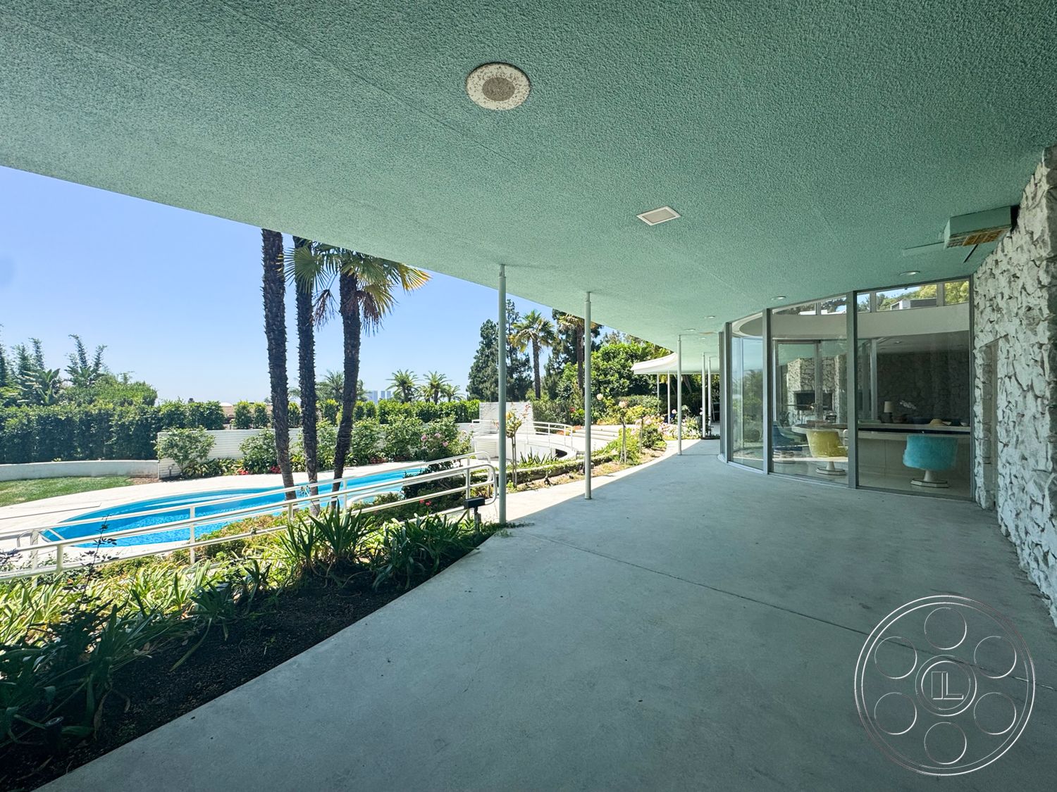 MCM 28 - exterior, palm trees, rectangular swimming pool, floor-to-ceiling windows, vaulted ceiling, modern architectural style, urban view, concrete patio flooring, landscaped garden setting, exposed stone walls