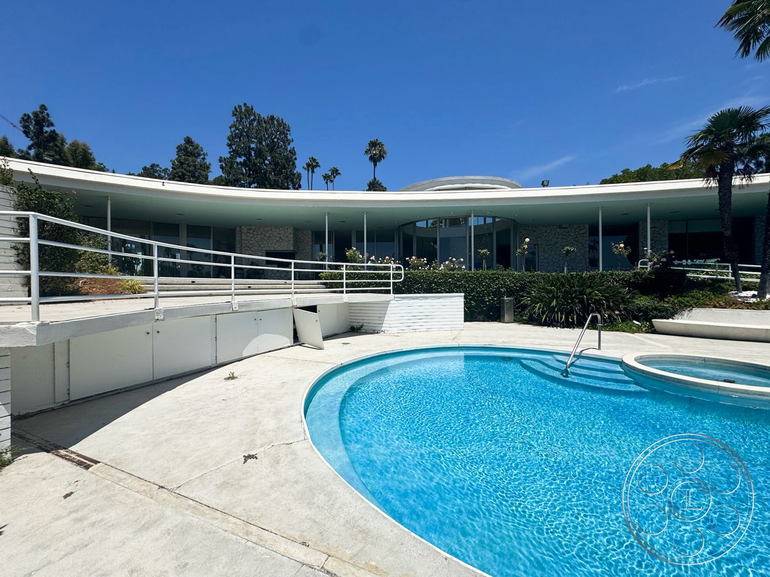 MCM 28 - exterior, landscaped garden, glass windows, tropical palm trees, concrete pool deck, stone feature wall, round swimming pool, modern architectural design, curved patio area, minimalist railing