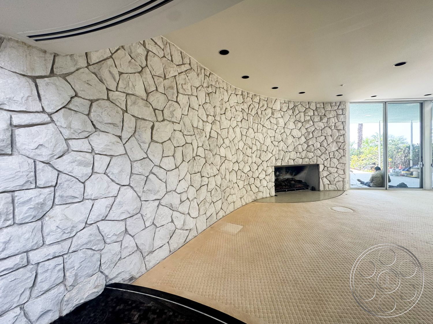 MCM 28 - open floor plan, modern aesthetic, floor-to-ceiling windows, curved wall design, built-in fireplace, recessed ceiling lights, textured stone feature wall, neutral carpet flooring