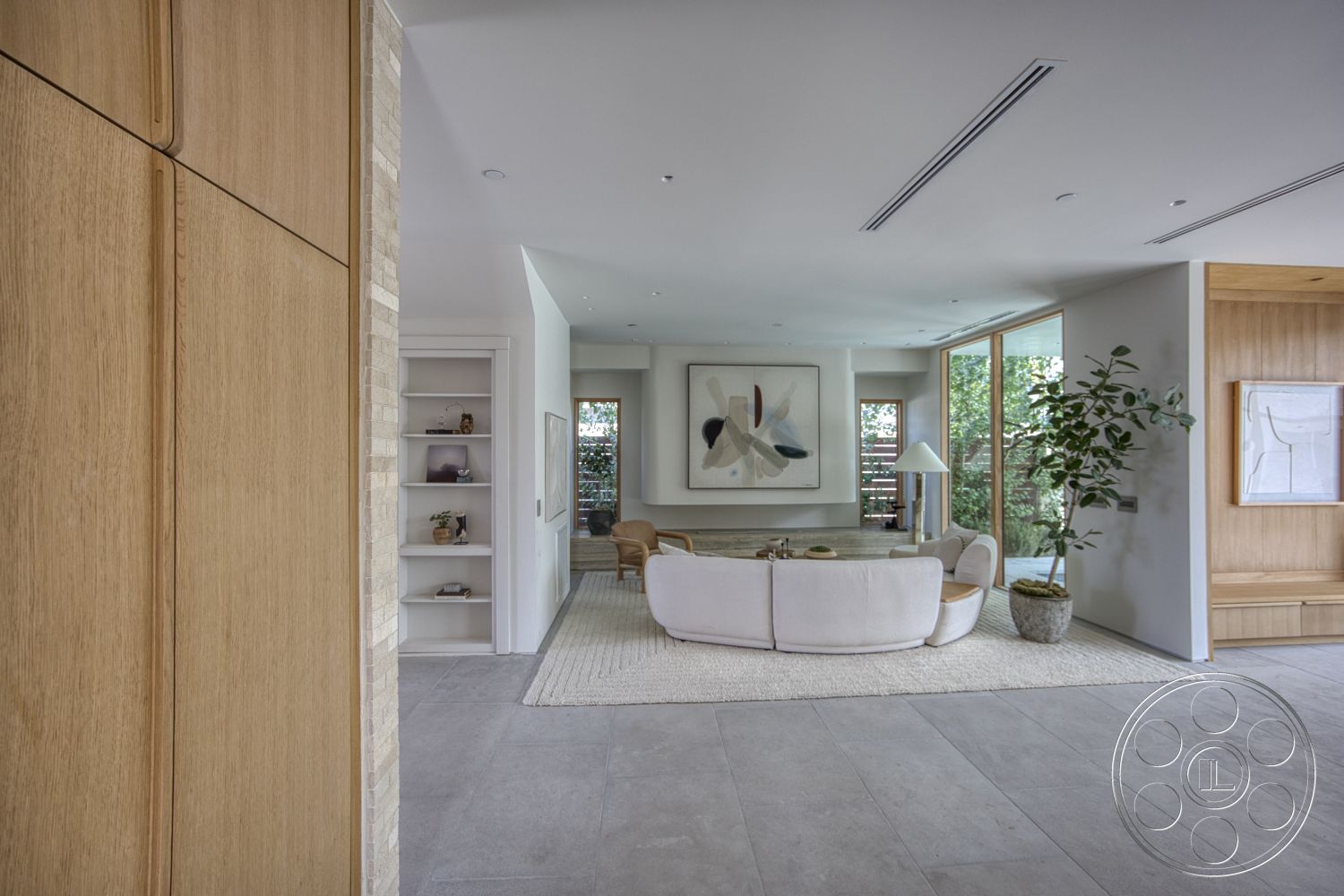 Modern 526 - natural wood cabinetry, neutral area rug, textured wall paneling, open concept living space, bright and airy atmosphere, large floor-to-ceiling windows, stone feature wall, curved sectional sofa, potted indoor plants, minimalist wall art, built-in shelving unit, soft grey tile flooring, plank ceiling beams