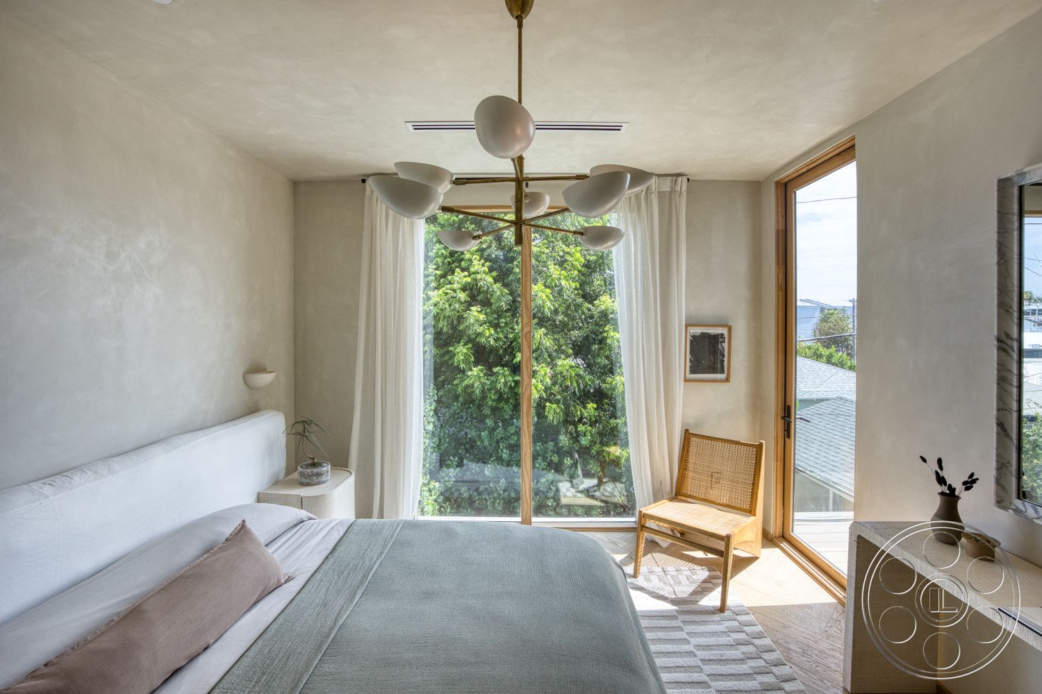 Modern 526 - minimalist decor, natural light, plant decor, light beige bedding, woven area rug, modern chandelier, large floor-to-ceiling windows, wooden chair, wood window frames, light wood nightstand, plaster textured walls