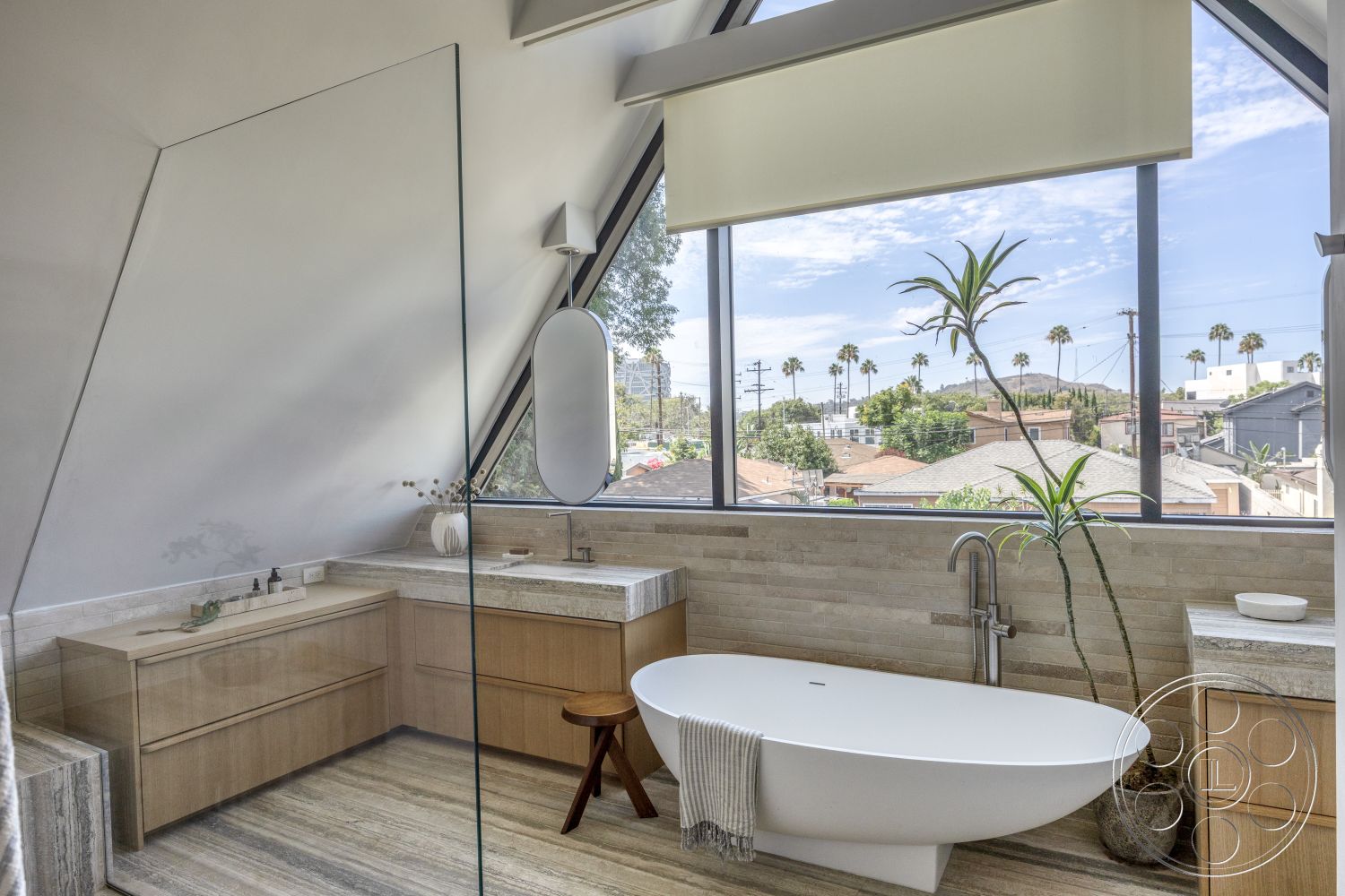 Modern 526 - neutral color palette, natural light, minimalist design, textured stone wall, spa-like atmosphere, modern fixtures, sloped ceiling, large floor-to-ceiling windows, freestanding soaking tub, glass shower partition, rectangular bathroom layout, indoor plant accents, polished stone countertop, light wood bathroom cabinetry