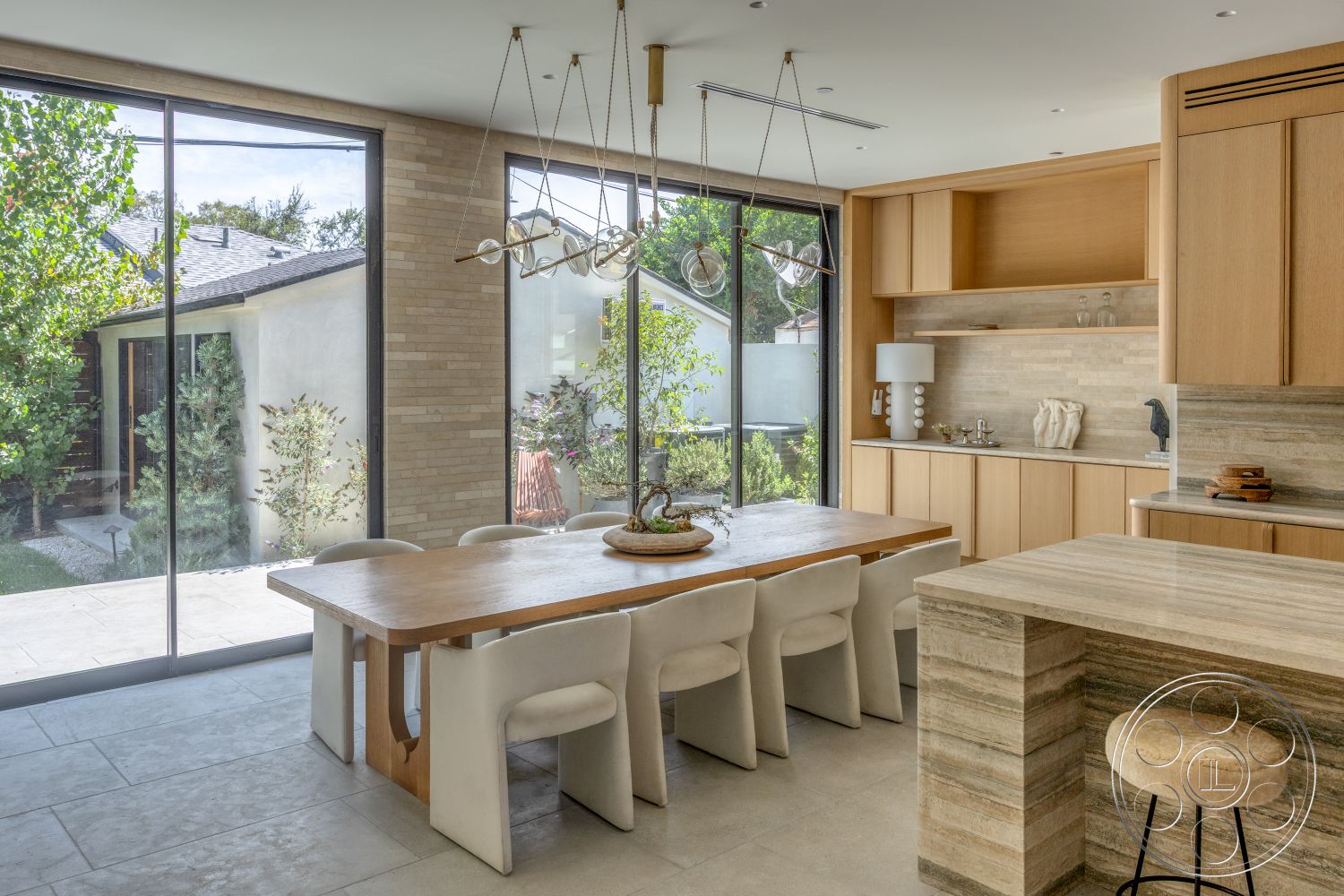 Modern 526 - neutral color palette, natural light, wood cabinetry, upholstered dining chairs, large glass windows, modern design elements, stone flooring, light wood dining table, textured stone backsplash, open kitchen layout, minimalist lighting fixtures, landscaped outdoor view