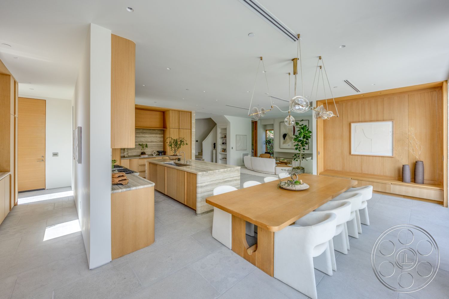 Modern 526 - neutral color palette, upholstered dining chairs, granite countertop, round dining table, natural light from large windows, textured plaster walls, glass pendant lighting, open concept dining area, indoor plants for decoration, contemporary art wall decor, marble kitchen island, light wood kitchen cabinetry, large format tile flooring, built-in living room shelving