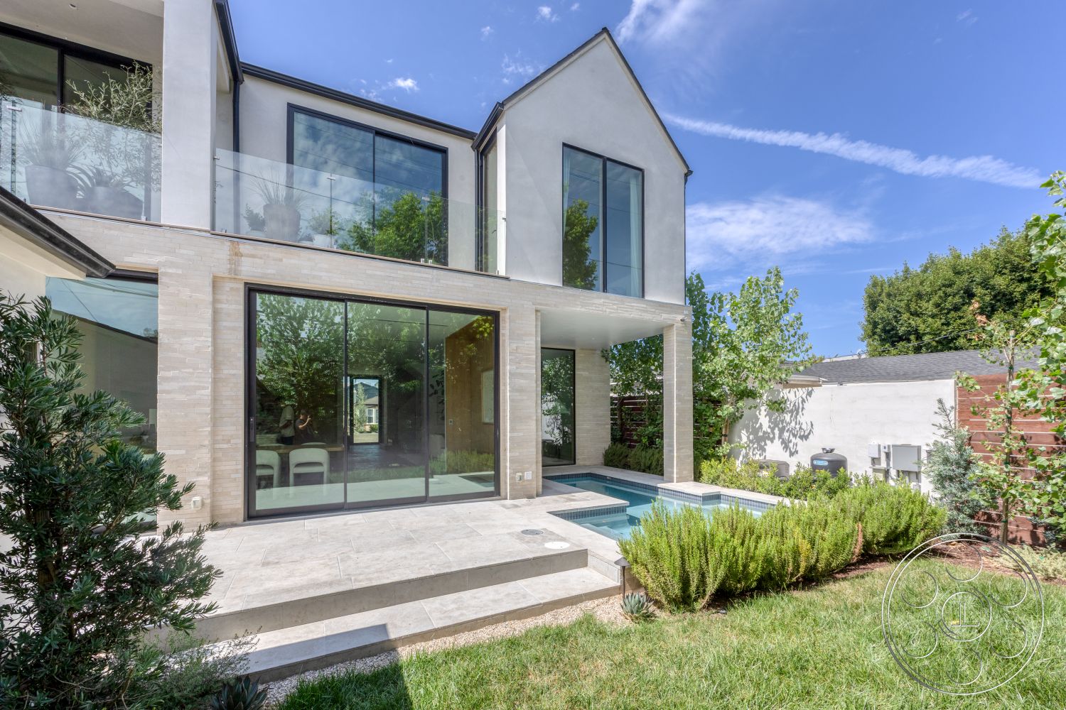 Modern 526 - exterior, white stucco walls, glass sliding doors, rectangular swimming pool, modern architectural style, lawn area, tall windows, minimalist landscaping, stone pool deck, flat roof design, concrete patio flooring, decorative shrubbery