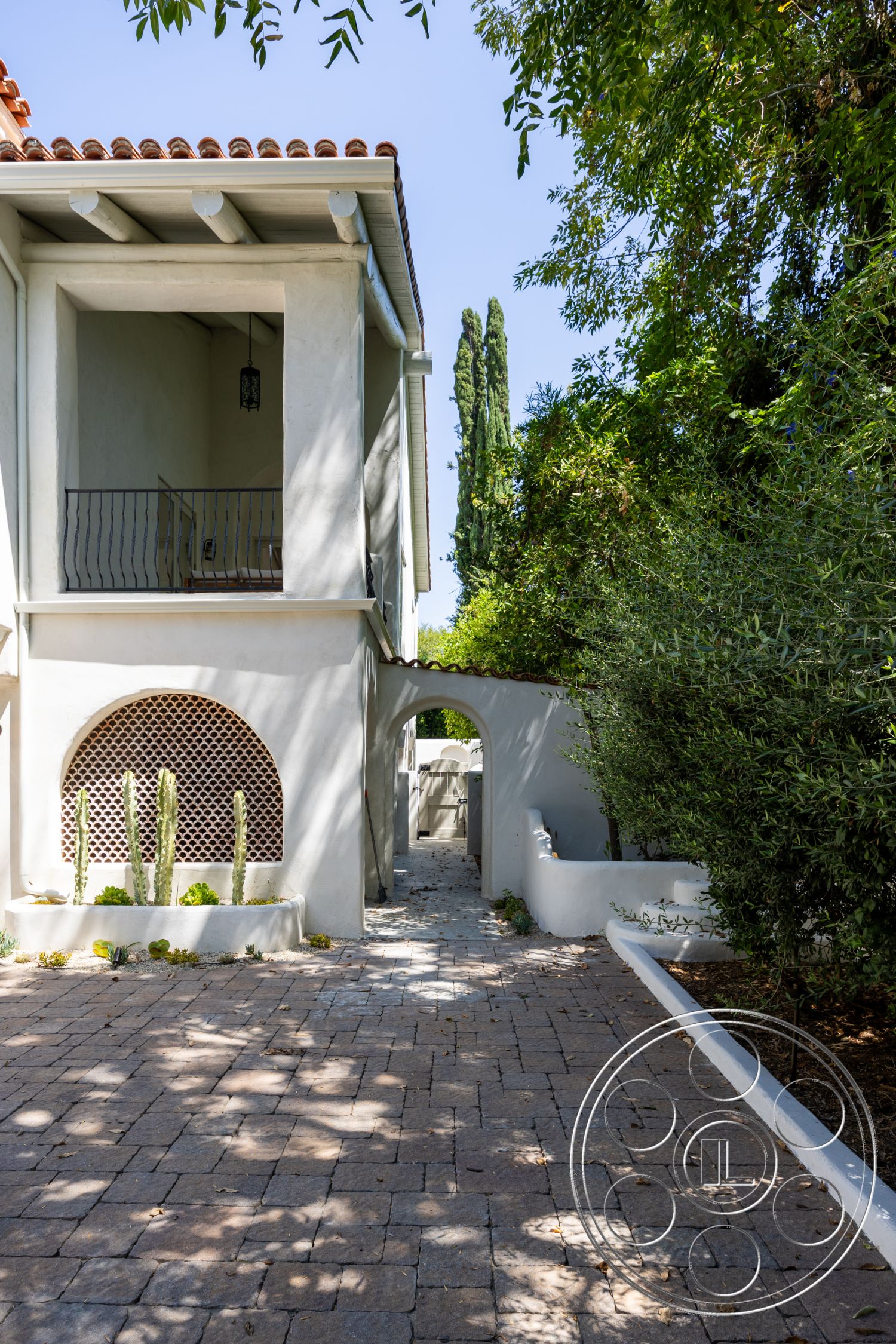 Medit 168 - exterior, surrounding greenery, metal railing, patio area, desert landscaping, stucco walls, arched doorway, red clay tile roof, cactus plants, Mediterranean architectural style, curved wall, paver stone pathway, arched window details, outdoor lighting fixture