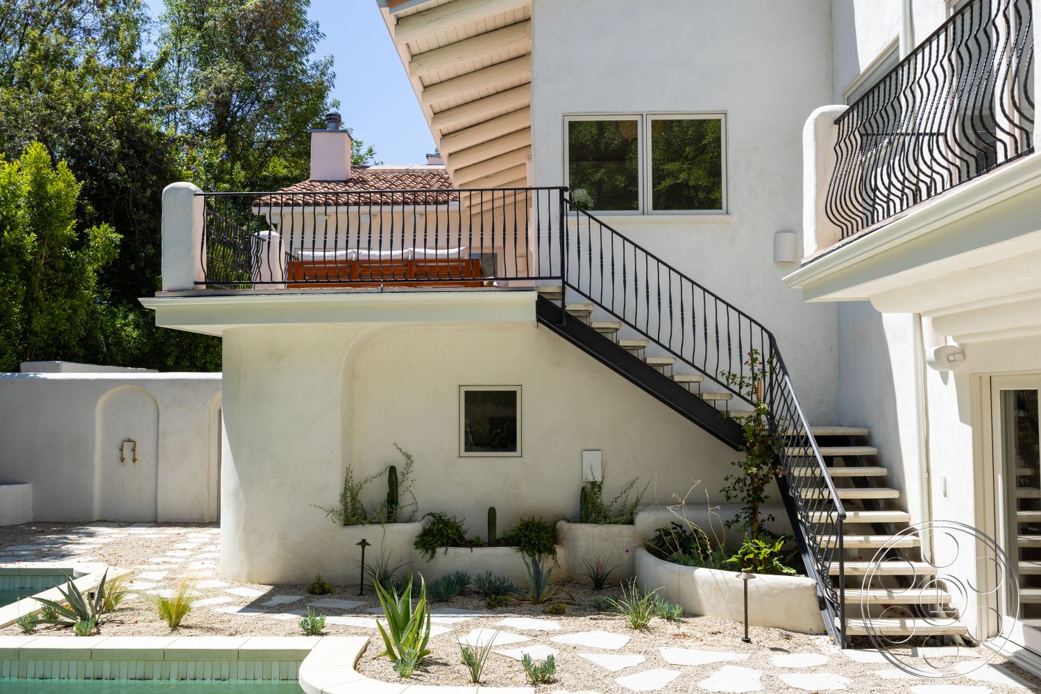 Medit 168 - exterior, floor-to-ceiling windows, modern architectural style, stucco walls, tile roof, rectangular pool, concrete patio flooring, minimalist outdoor design, landscaped garden with succulents, decorative concrete steps, wooden balcony, iron staircase railings, geometric stepping stones, open-air deck