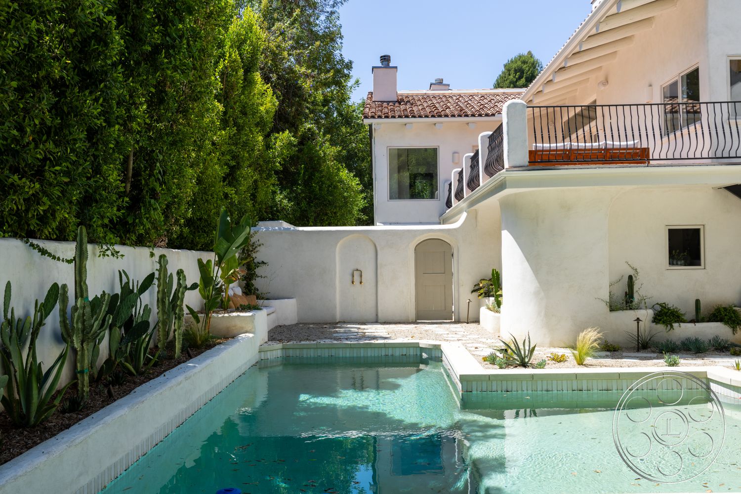 Medit 168 - neutral color palette, exterior, outdoor seating area, green landscaping, floor-to-ceiling windows, plaster walls, terracotta roof tiles, potted succulents, arched doorway, residential backyard, rectangular pool, stone patio flooring, tile pool border, angled roof design, wood balcony railing
