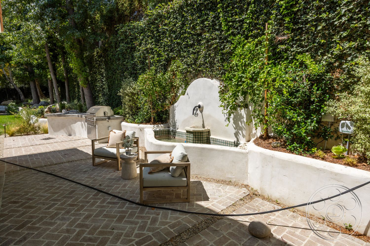 Medit 168 - exterior, natural stone planters, greenery landscaping, wooden outdoor furniture, brick patio flooring, sunlit outdoor space, stone garden accents, curved patio layout, stucco wall fountain, tiled water feature, lush ivy wall, charcoal grill