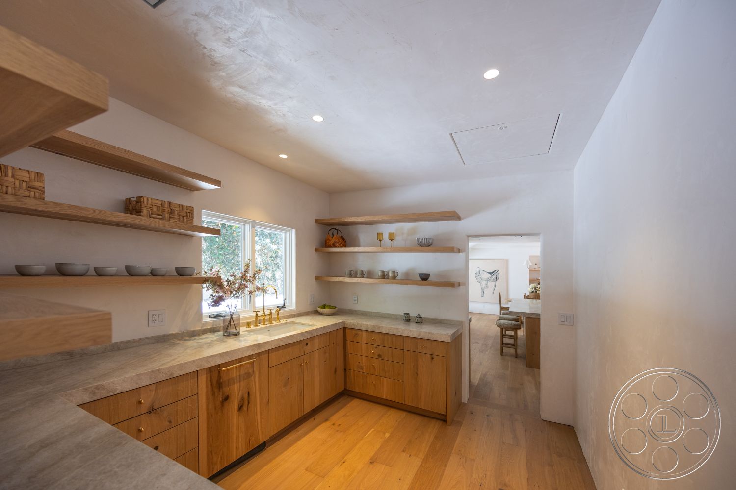 Medit 168 - neutral color palette, wood cabinetry, natural wood flooring, floor-to-ceiling window, modern minimalist design, white textured plaster walls, large window with outdoor view, concrete kitchen countertops, brushed gold hardware, light wood open shelving