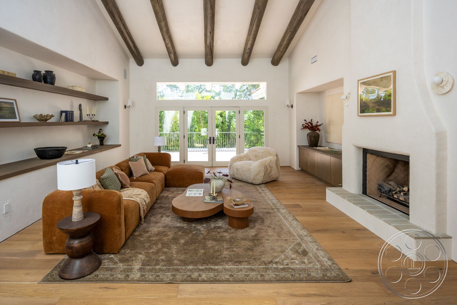 Medit 168 - textured area rug, open floor plan, sliding glass doors, white plaster walls, contemporary coffee table, exposed wood ceiling beams, hardwood living room floors, stone fireplace surround, modern accent furniture, built-in shelf details