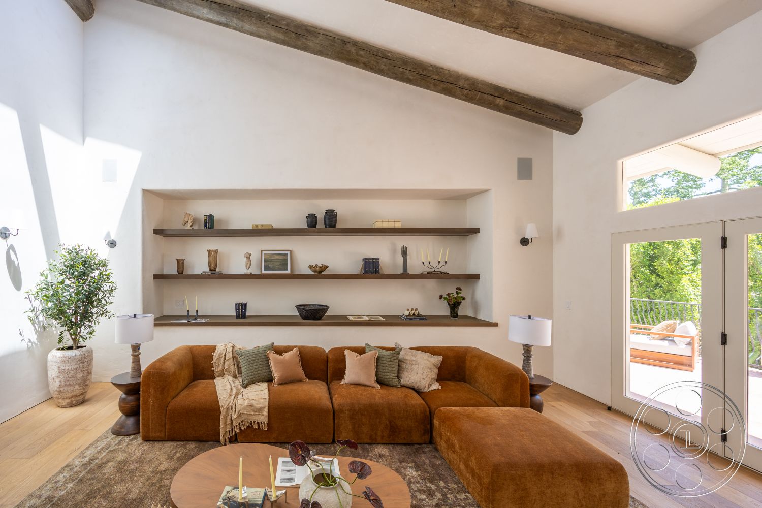 Medit 168 - hardwood flooring, indoor plant, round coffee table, floor-to-ceiling windows, textured plaster walls, soft lighting fixtures, decorative wall shelves, exposed wood ceiling beams, modern sectional sofa, patio door, art and decorative items on shelves